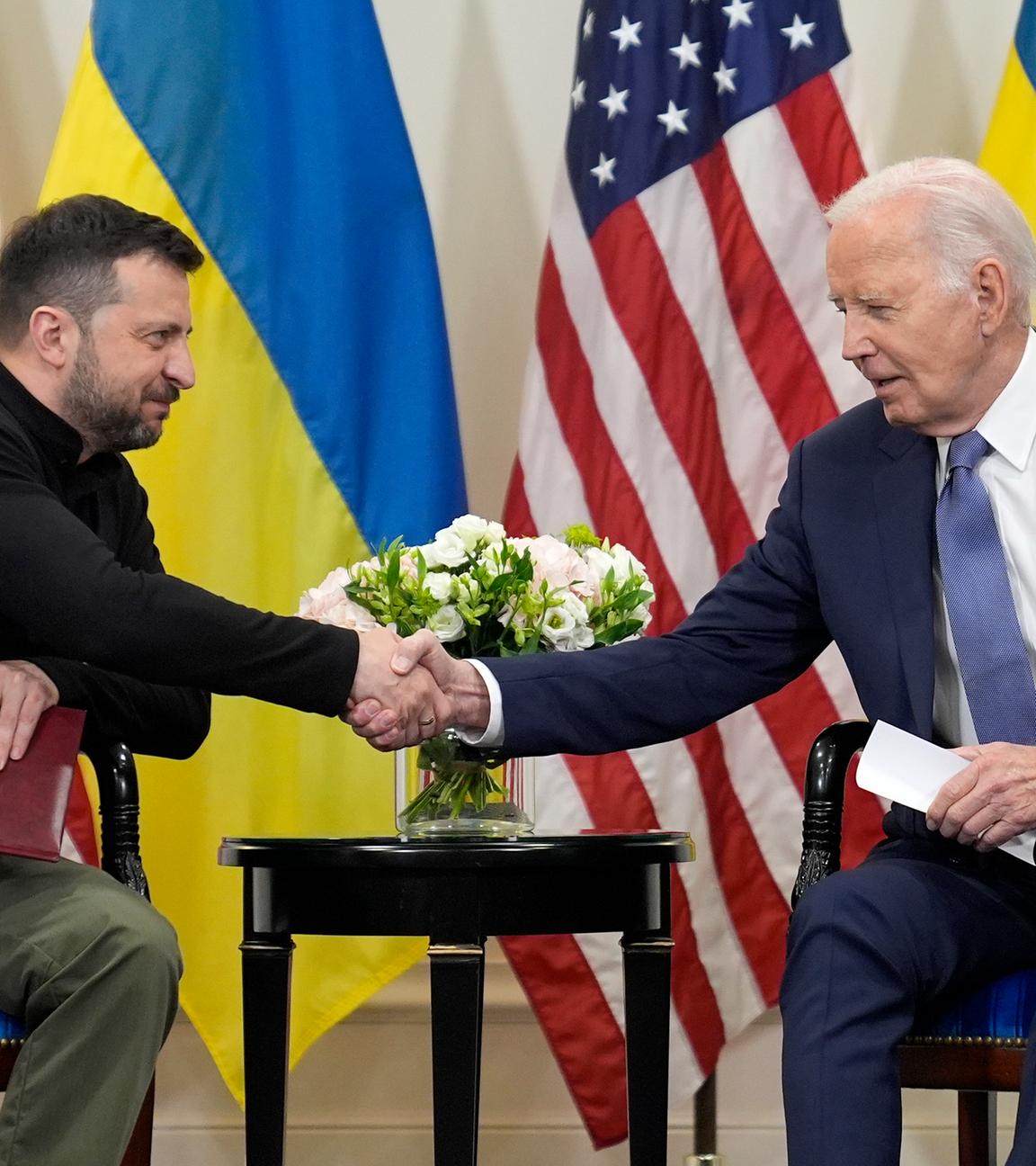 Der ukrainische Präsident Wolodymyr Selenskyj (links) schüttelt in Paris die Hand von US-Präsident Joe Biden (rechts).
