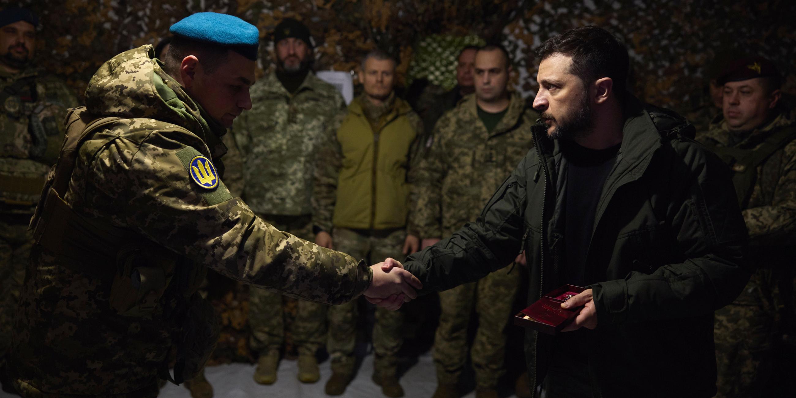 Ukraine, Pokrowsk: Auf diesem vom Pressebüro des ukrainischen Präsidenten zur Verfügung gestellten Foto zeichnet der ukrainische Präsident Wolodymyr Selenskyj (r) Soldaten in der Frontstadt Pokrowsk aus, dem Schauplatz der schwersten Kämpfe mit den russischen Truppen in der Region Donezk.