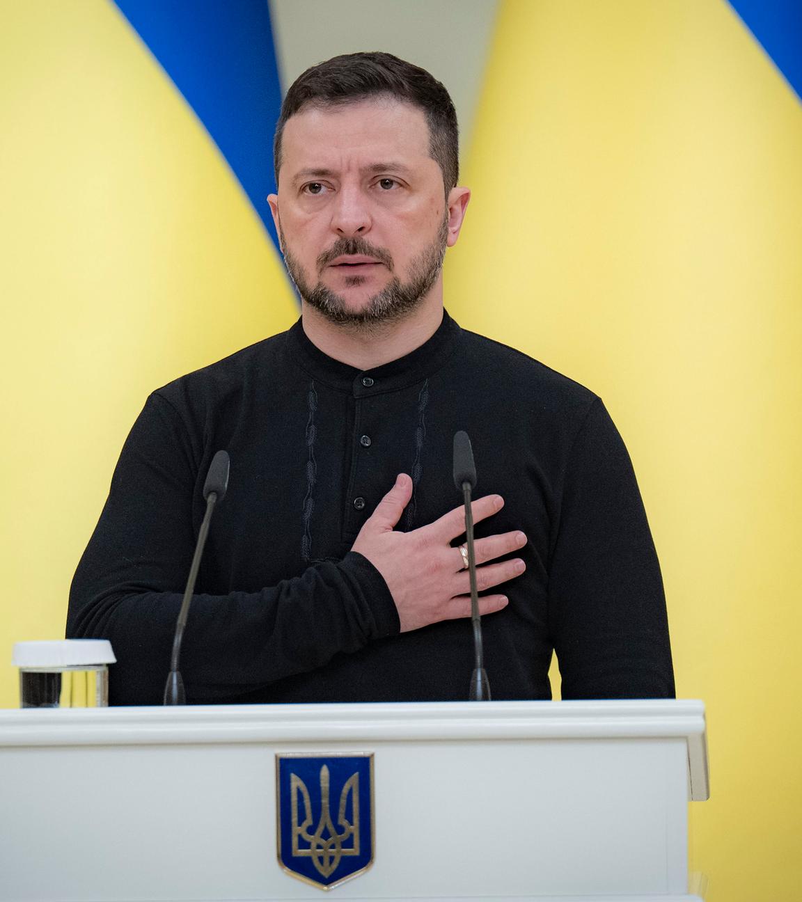 Ukraine, Kiew: Wolodymyr Selenskyj, Präsident der Ukraine, steht beim Abspielen der Nationalhymne, bevor er während einer Zeremonie im Mariinskyi-Palast den Helden der Ukraine und den Familien der gefallenen Soldaten Urkunden für kostenlose Wohnungen überreicht.