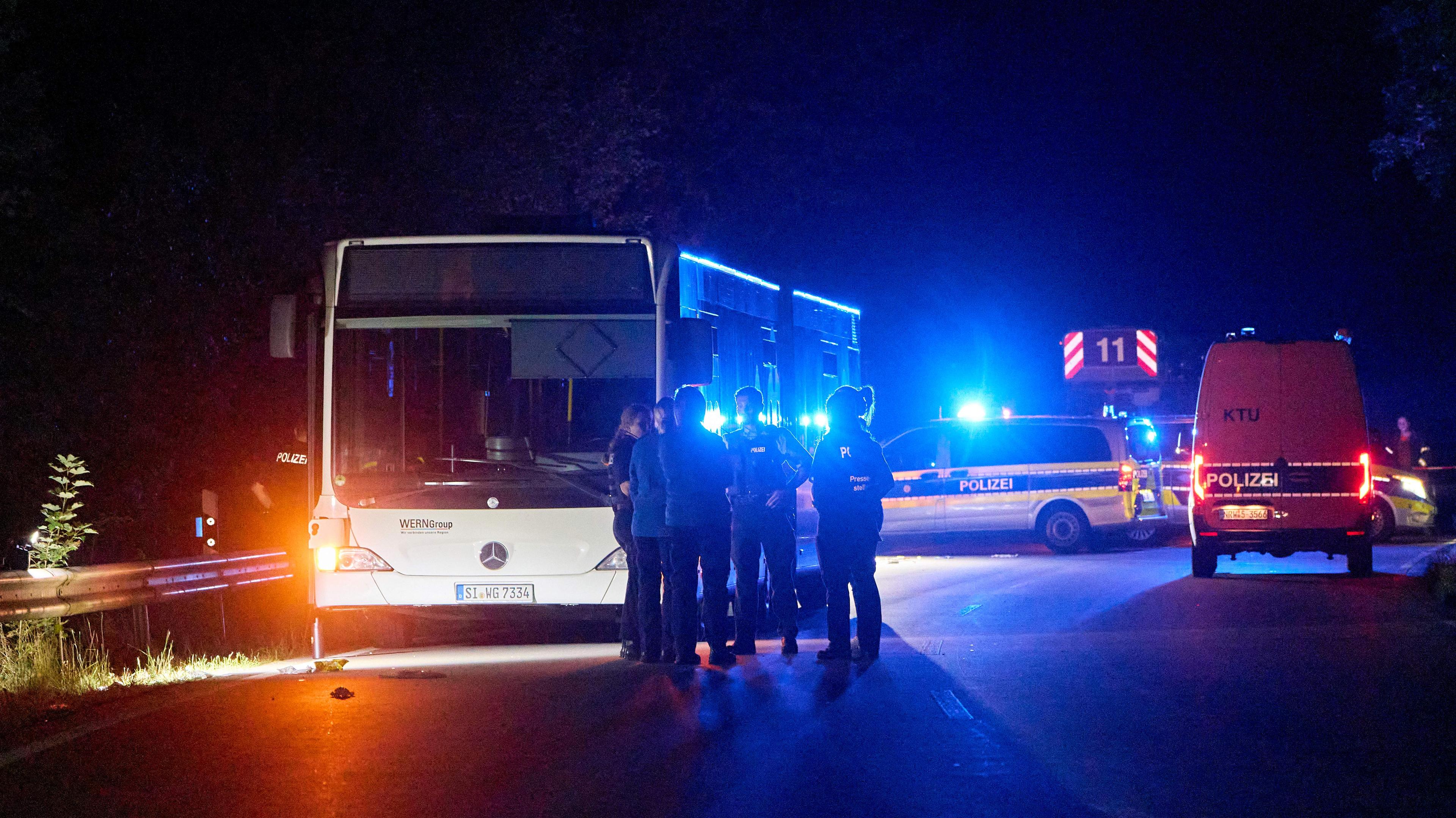 30.08.2024, Nordrhein-Westfalen, Siegen: Polizisten stehen vor einem Bus, der auf einer Sonderlinie zu einem Stadtfest fahren sollte. Eine 32-jährige Tatverdächtige habe in dem Bus andere Fahrgäste mutmaßlich mit einem Messer angegriffen.