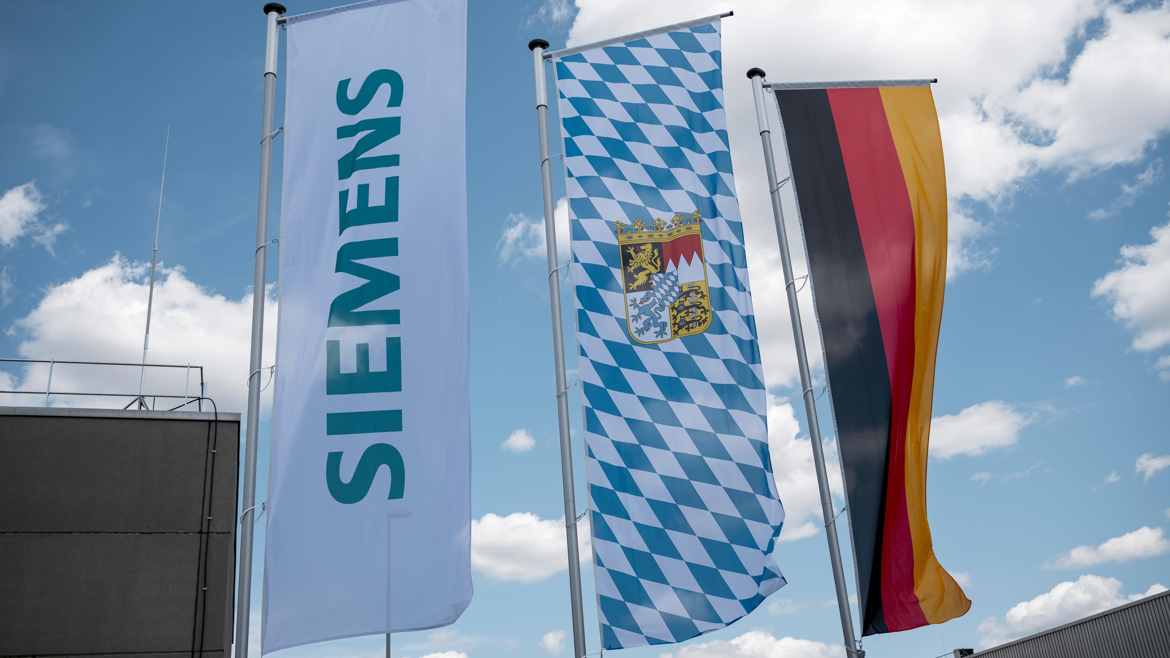 ie Fahnen des Unternehmens Siemens, die Fahne des Freistaats Bayern und die Deutschlandfahne wehen auf dem Gelände der Siemens AG.