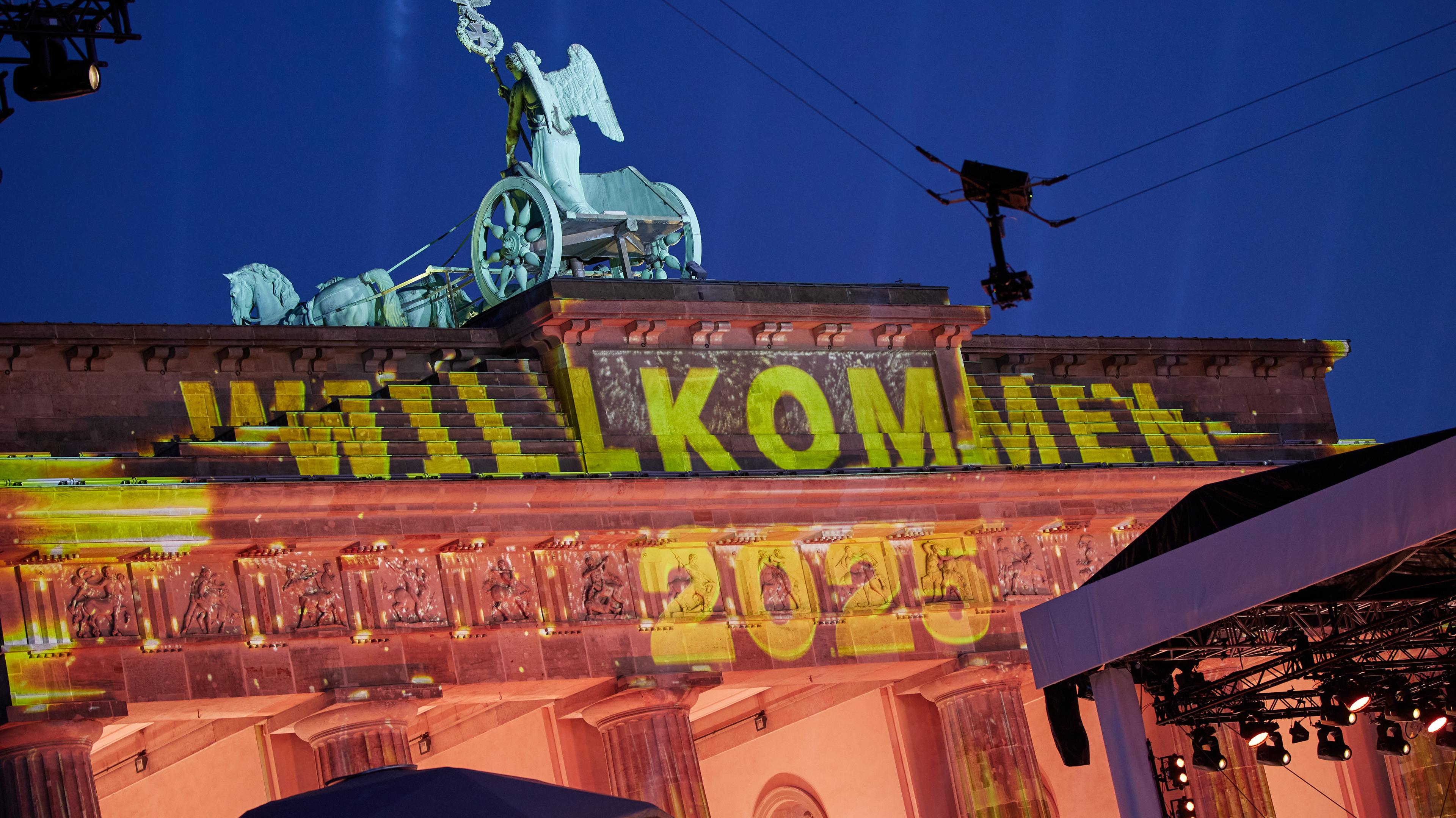 Das Brandenburger Tor ist mit dem Schriftzug "Willkommen 2025" angestrahlt