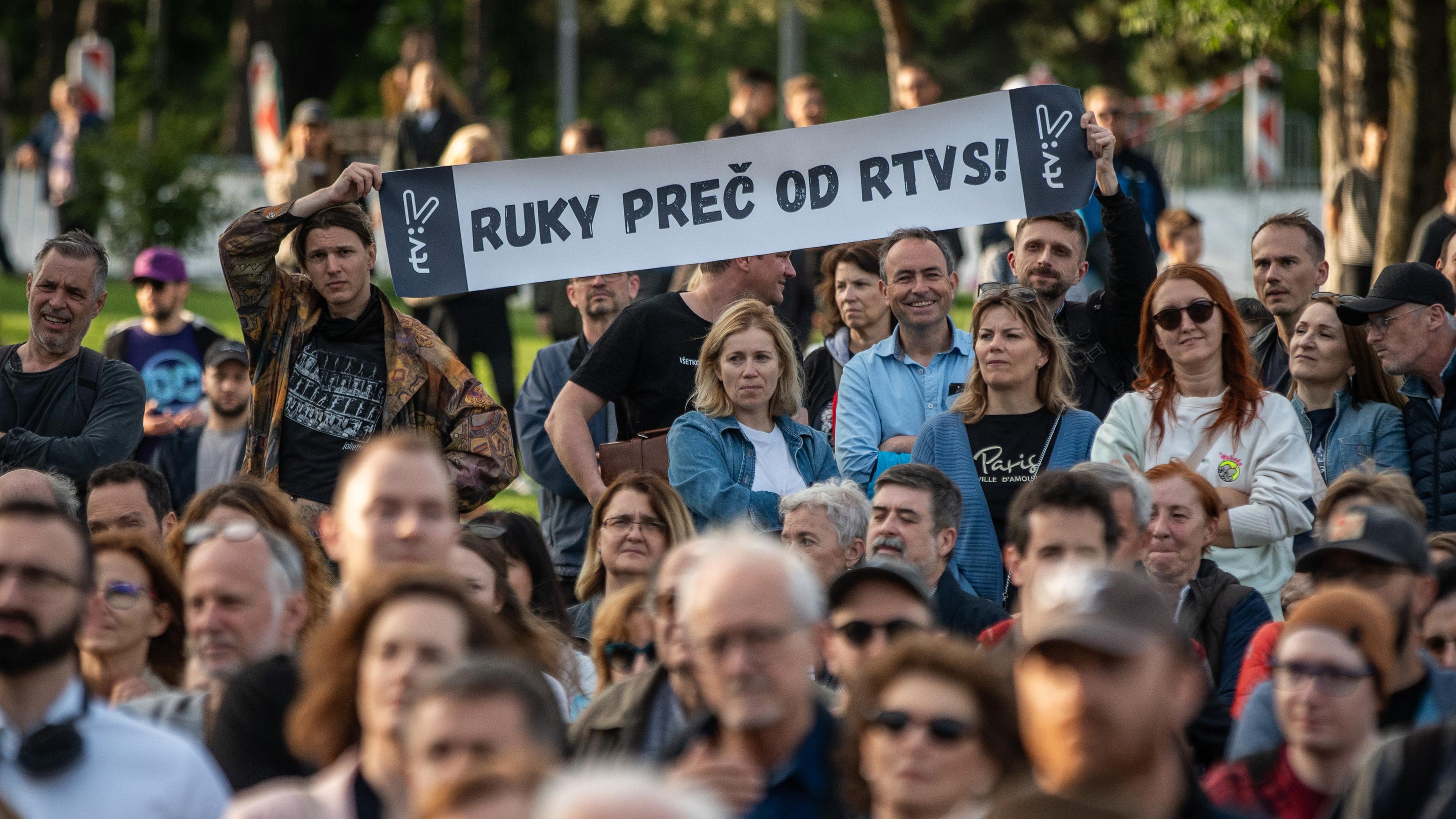 Eine Menschenmenge protestiert gegen die Abschaffung öffentlich-rechtlicher Medien in Bratislava. Sie halten ein Banner mit der Aufschrift "Hände weg von RTVS" (übersetzt).