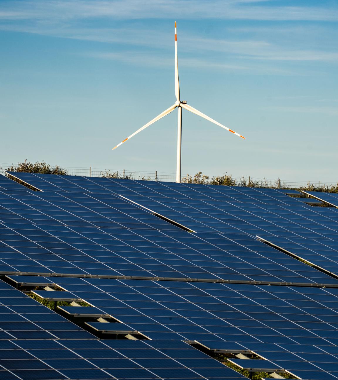 10.11.2022, Rheinland-Pfalz, Freimersheim: Ein Windrad steht auf einem Hügel oberhalb einer großflächigen Solaranlage auf einem Feld im Landkreis Alzey-Worms. Klimaneutral erzeugter Strom hat 2023 erstmals mehr als die Hälfte des Stromverbrauchs in Deutschland gedeckt.