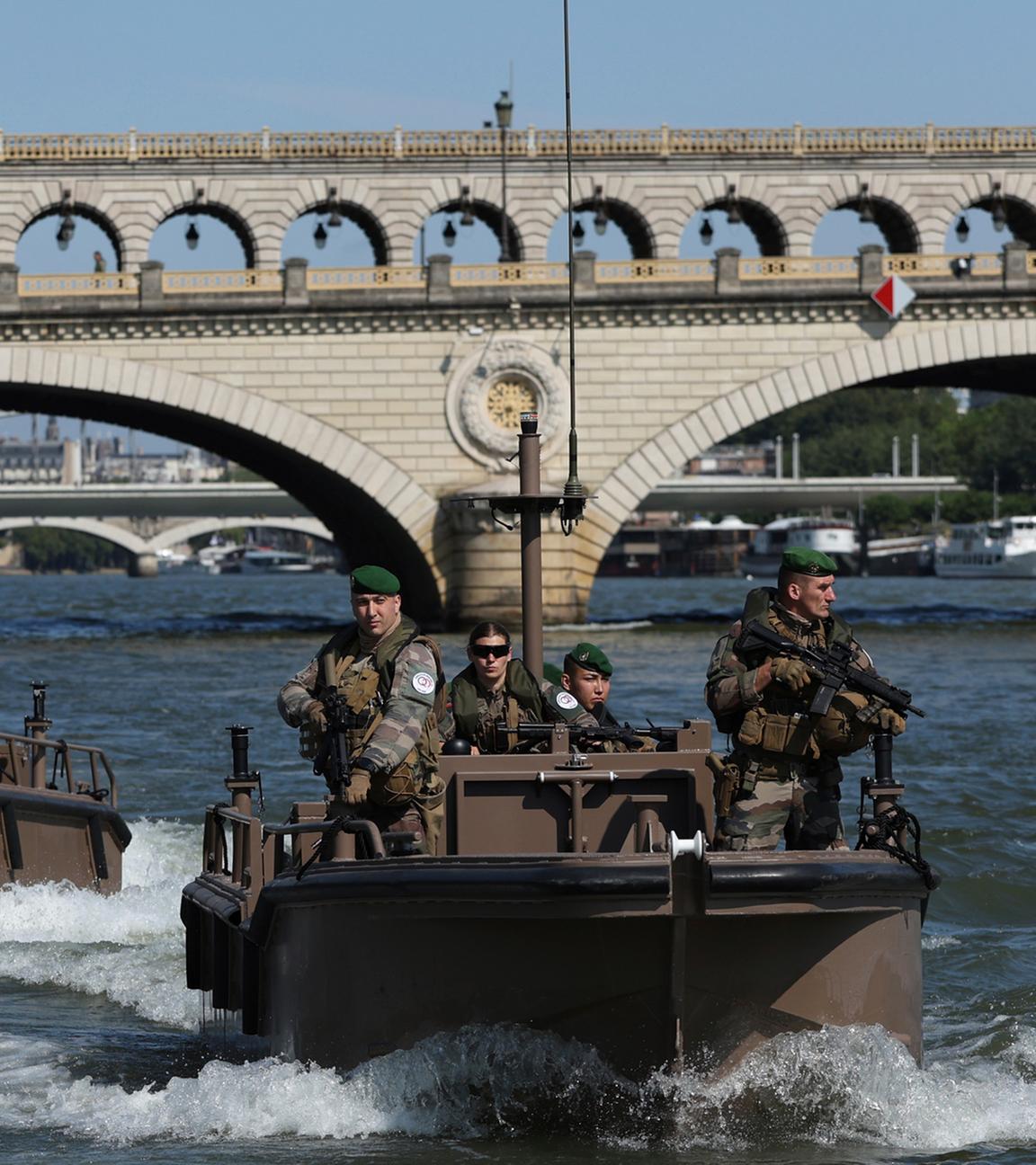 Soldaten patrouillieren mit Booten auf der Seine.