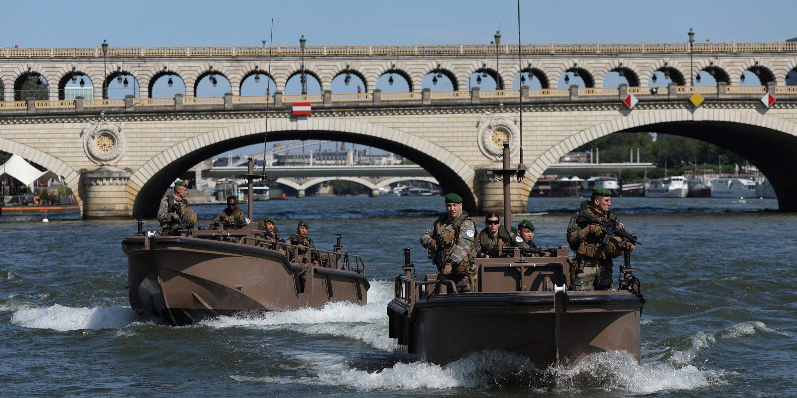 Soldaten patrouillieren mit Booten auf der Seine.
