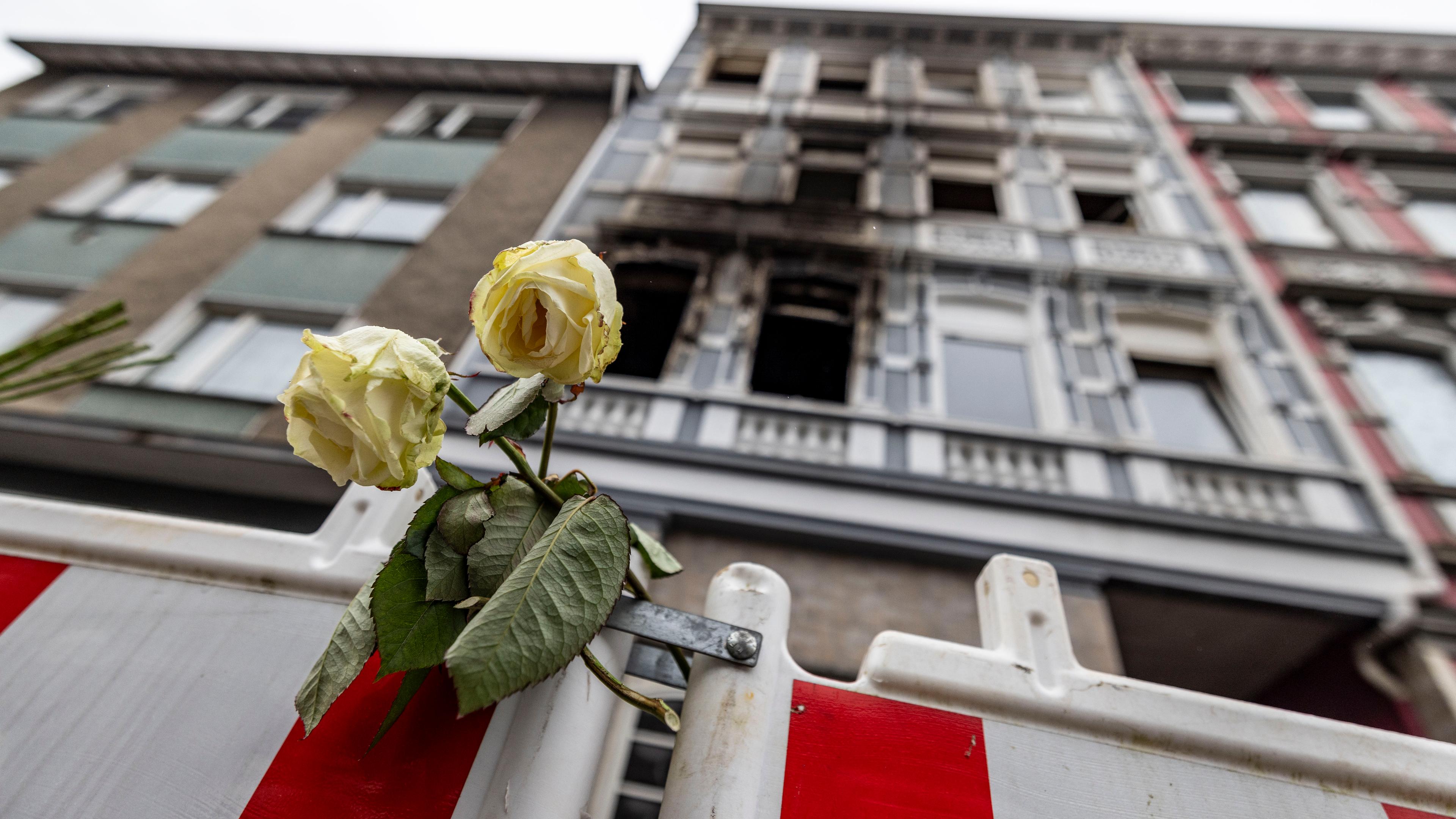 Eine weiße Rose an einer Absperrbake vor dem Brandort in Solingen nach dem Pressestatement der Staatsanwaltschaft Wuppertal zum tödlichen Brand in Solingen. In dem Feuer waren vier Menschen ums Leben gekommen, mehrere wurden verletzt.