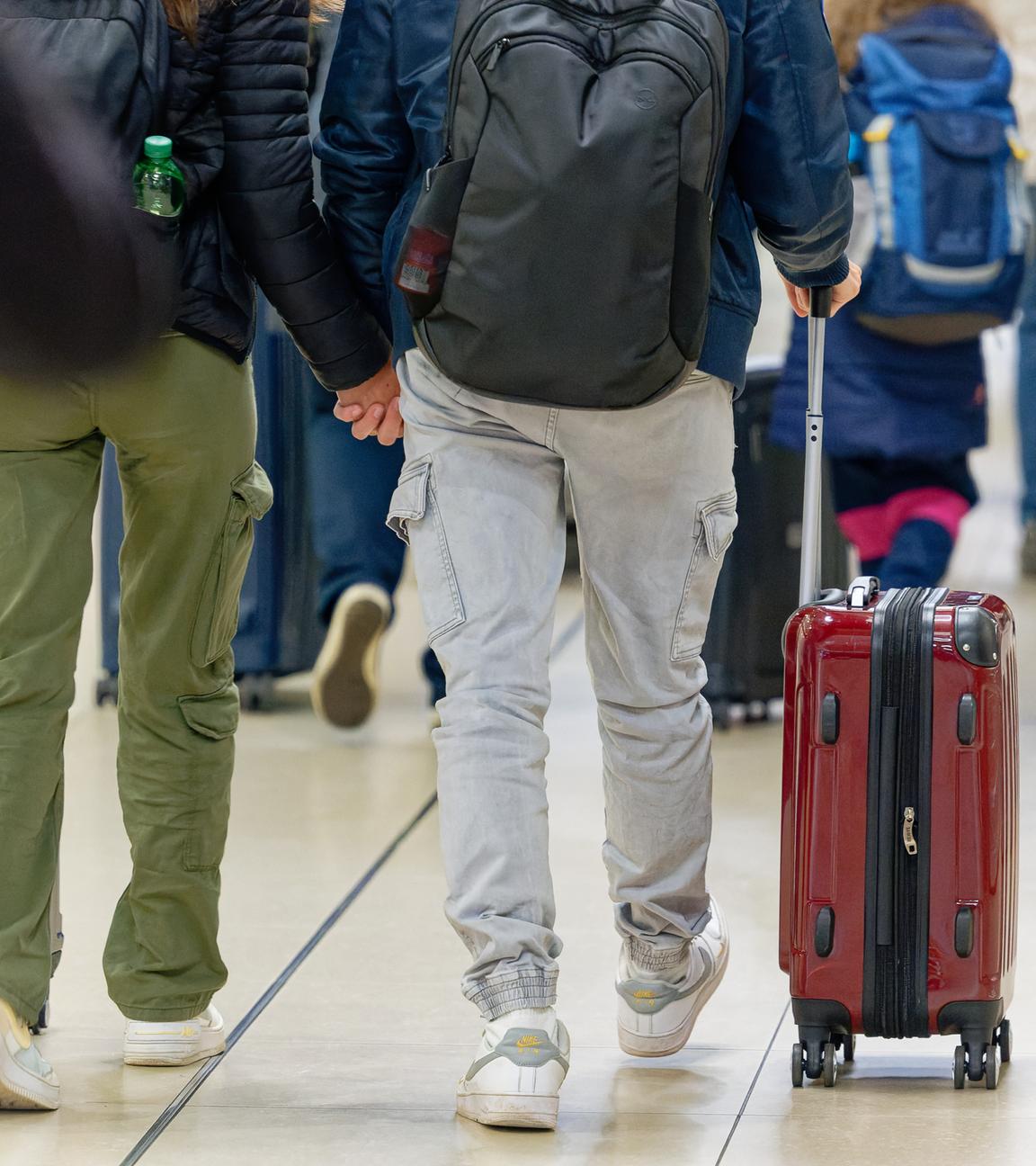 Reisenden gehen im Flughafen Köln/Bonn zu ihrem Gate.