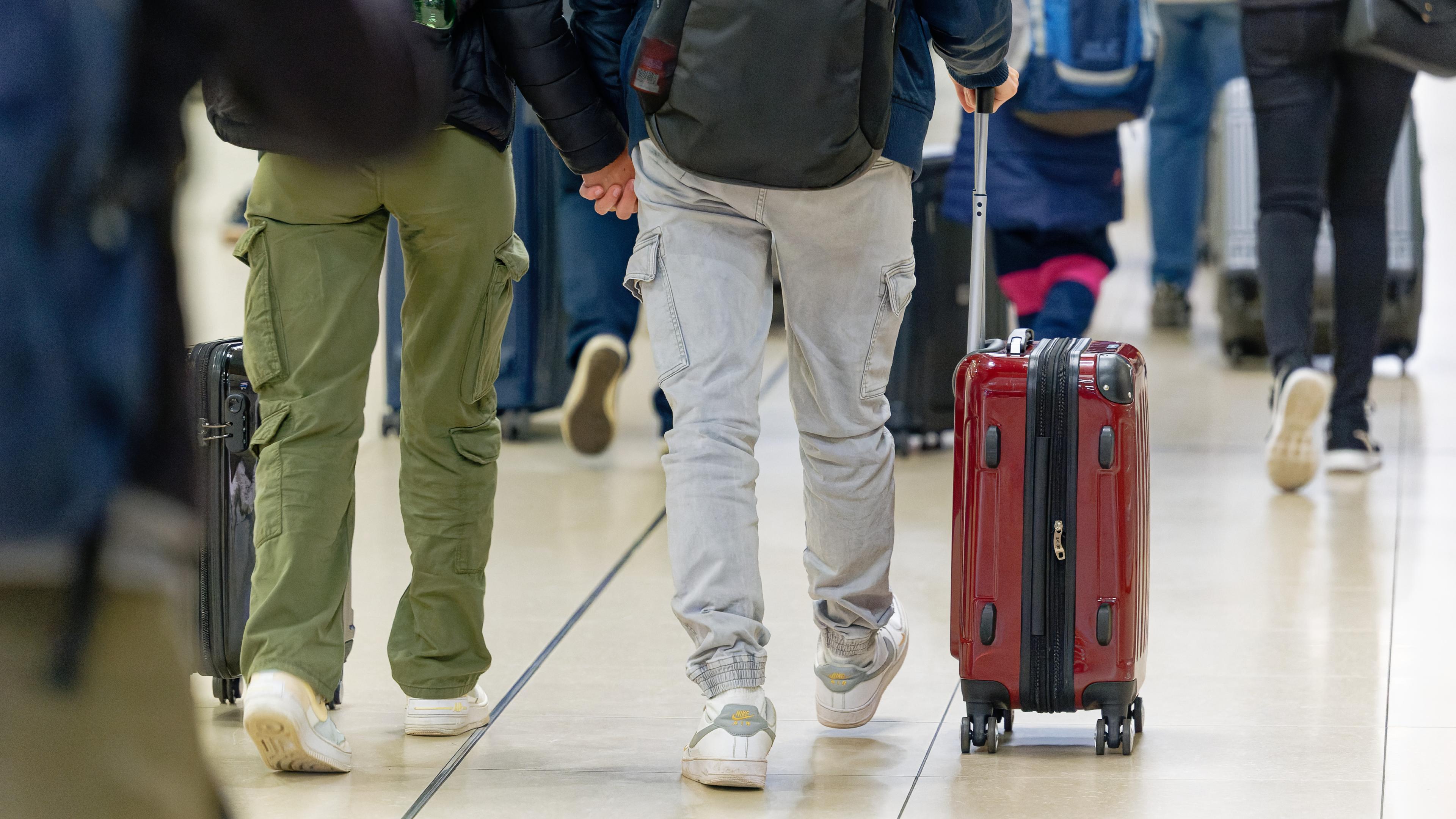 Reisenden gehen im Flughafen Köln/Bonn zu ihrem Gate.