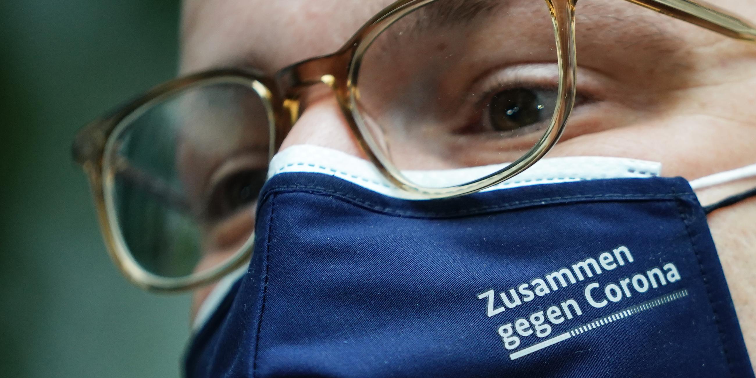 Jens Spahn (CDU), Bundesminister für Gesundheit, wartet vor seiner Pressekonferenz zum Impfstart in Hausarztpraxen mit einer Maske mit der Aufschrift ·Zusammen gegen Corona·. 