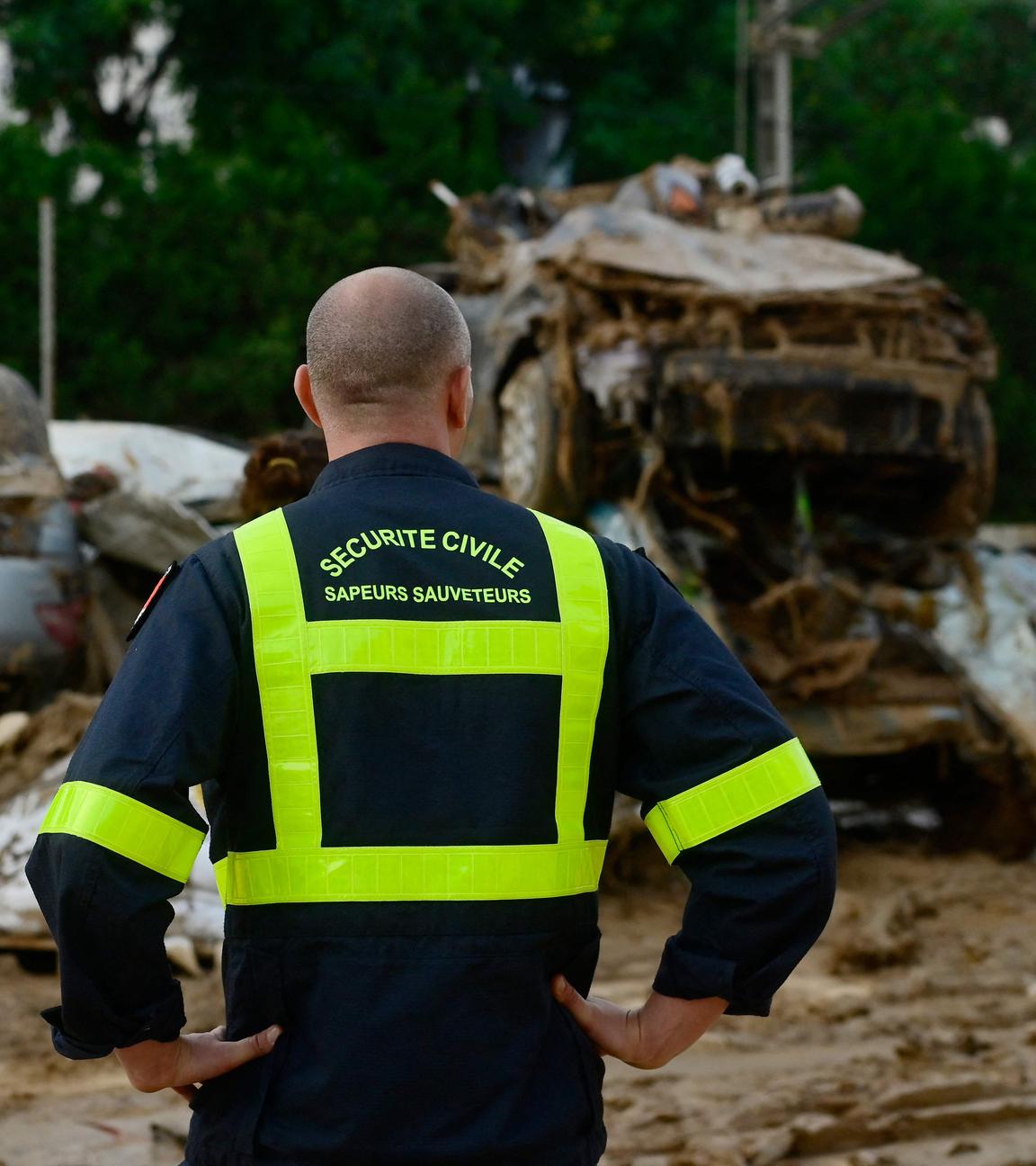 Ein französischer Feuerwehrmann blickt auf Auto-Wracks im Hintergrund nach den Überschwemmungen in Alfafar, südlich von Valencia.