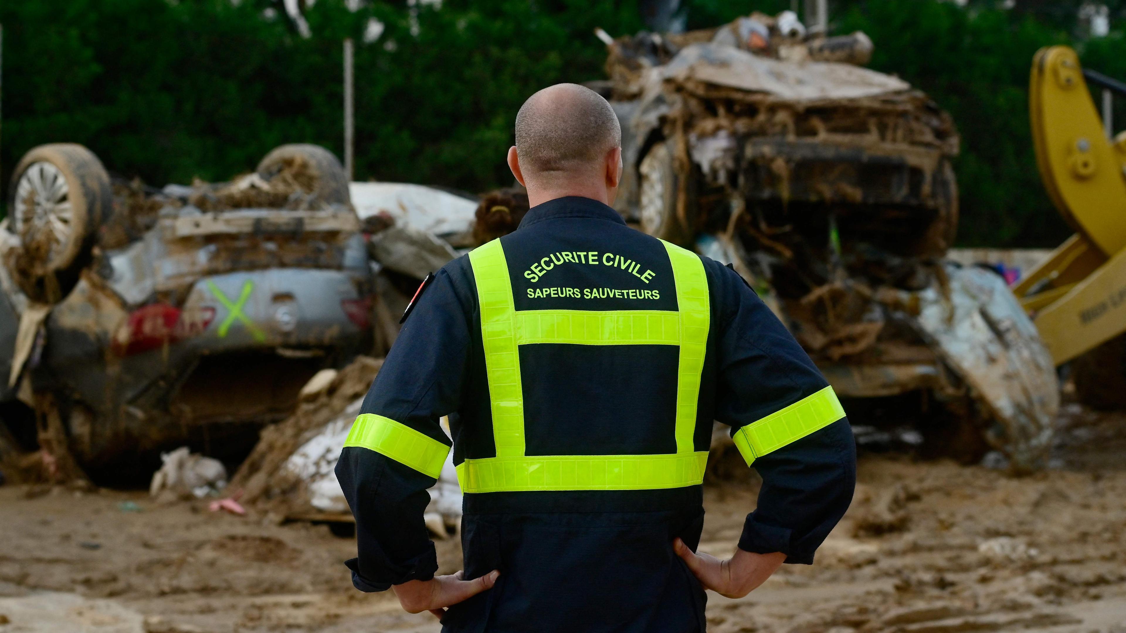 Ein französischer Feuerwehrmann blickt auf Auto-Wracks im Hintergrund nach den Überschwemmungen in Alfafar, südlich von Valencia.