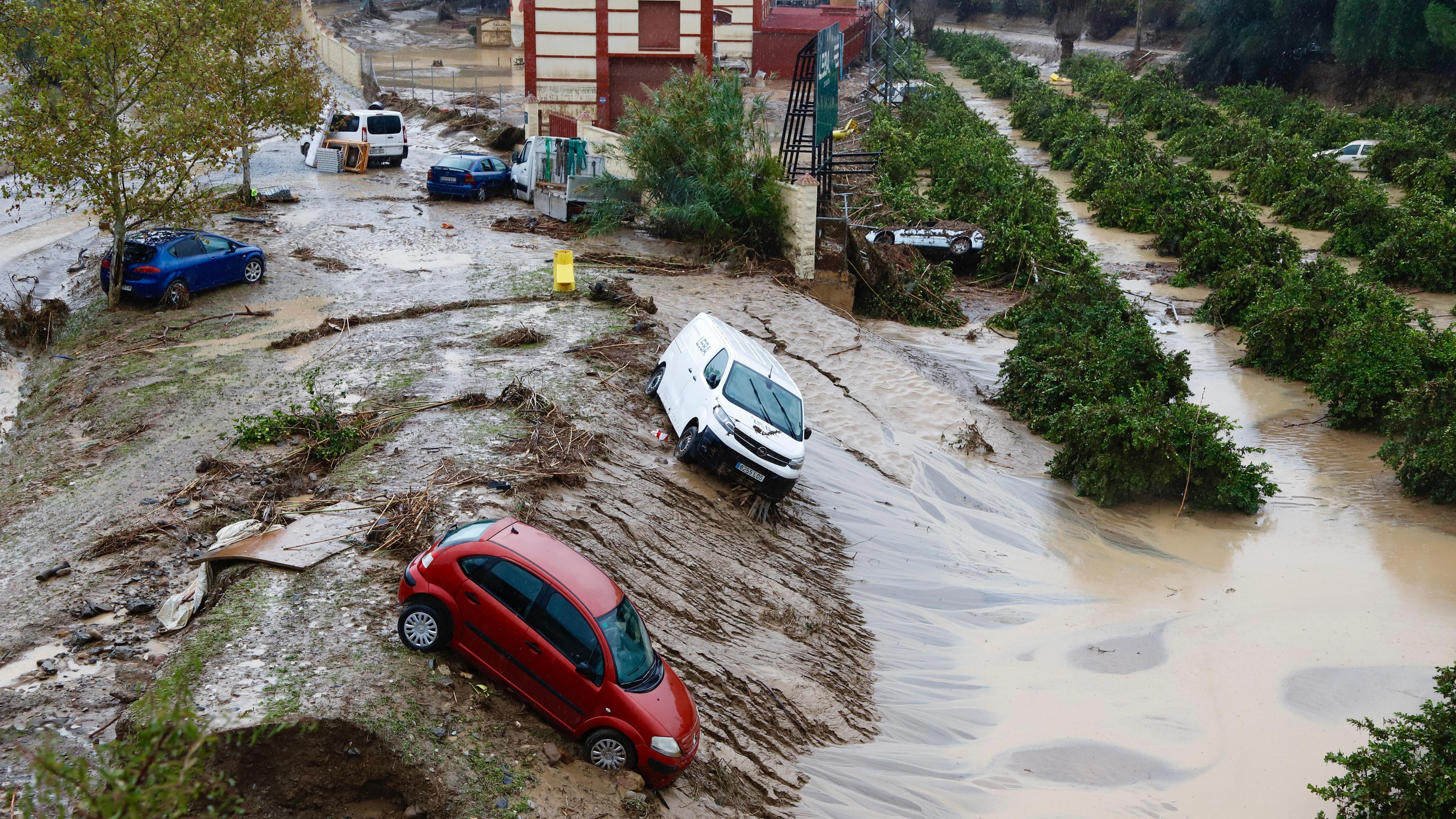 Autos stehen an Hängen, nachdem Wassermassen sie weggespült haben.