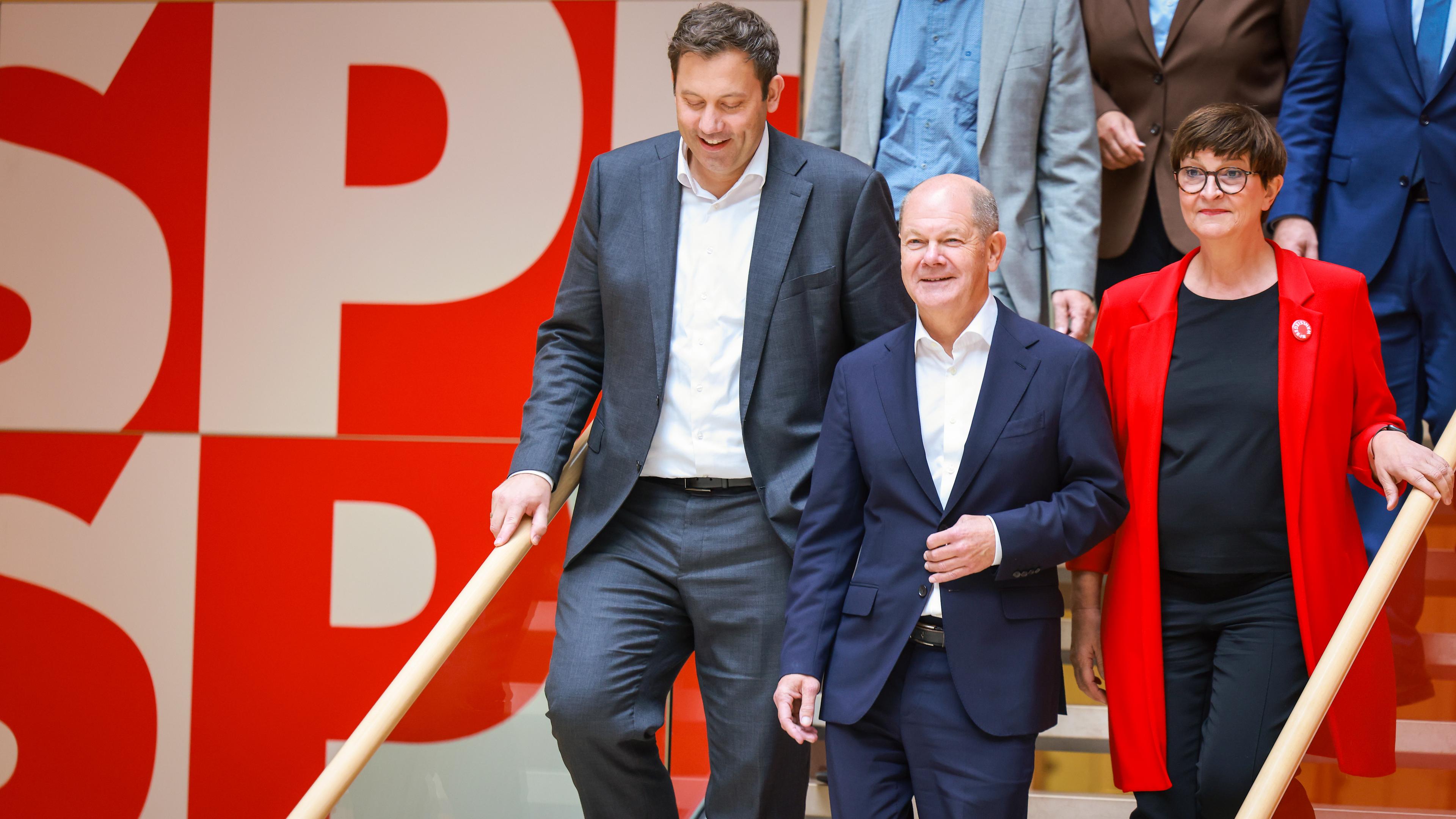 Kanzler Olaf Scholz (M) und die SPD-Vorsitzenden Lars Klingbeil (l) und Saskia Esken gehen eine Treppe hinunter.