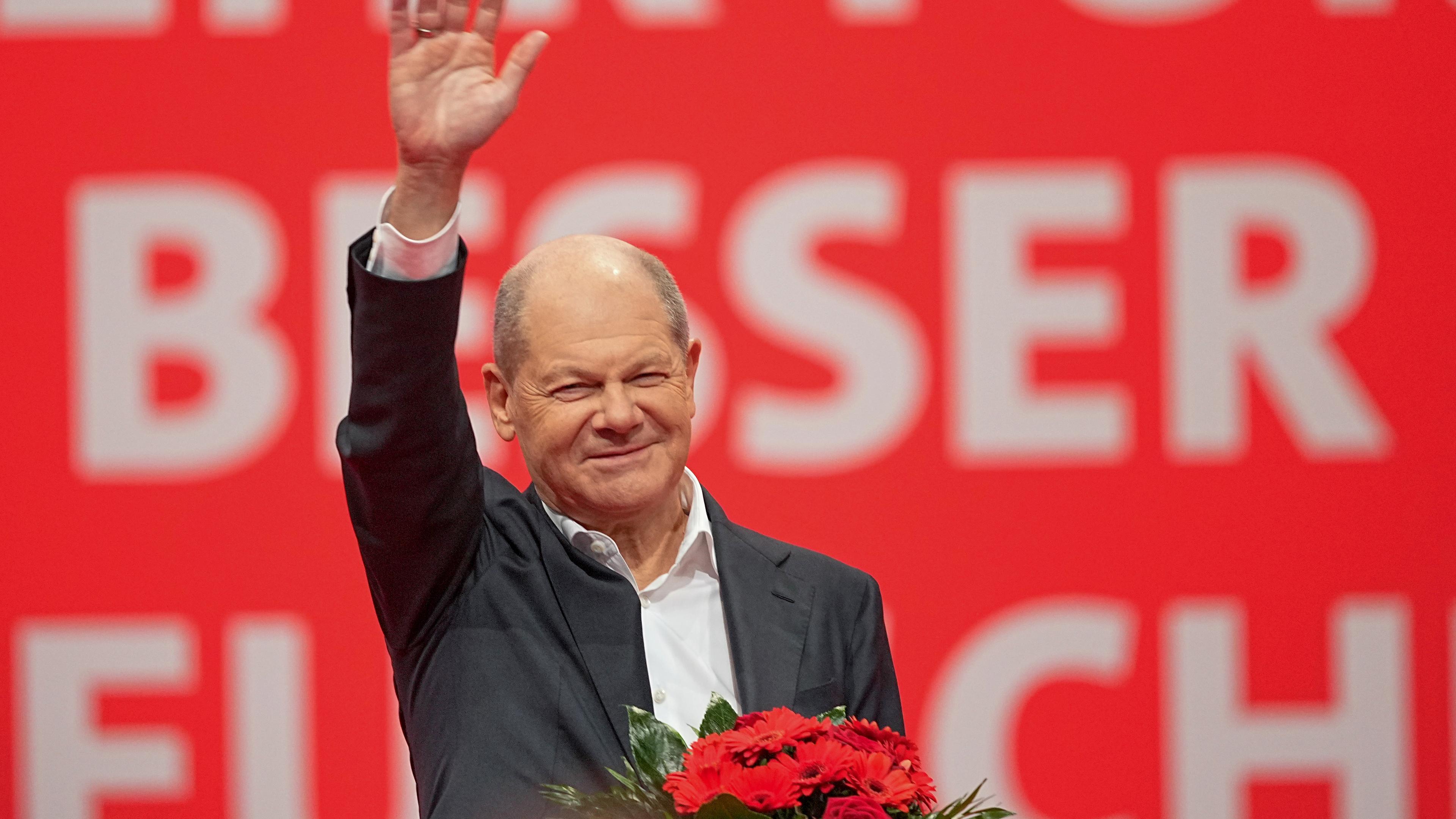 Bundeskanzler Olaf Scholz (SPD) winkt zu den Delegierten nach seiner Kür zum SPD-Kanzlerkandidaten beim außerordentlichen Bundesparteitag. 