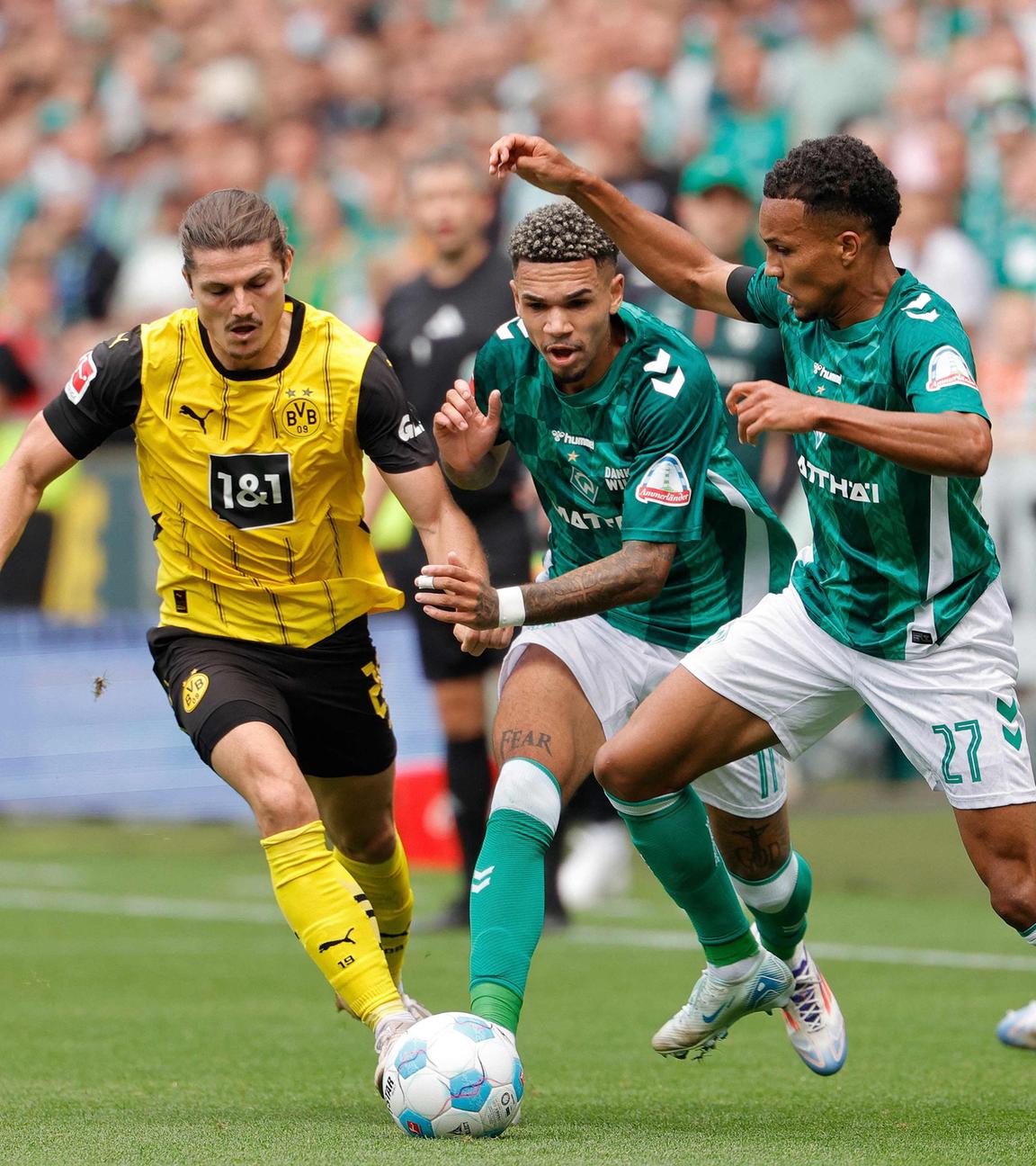 Dortmunds Mittelfeldspieler (Nr. 20) Marcel Sabitzer, Bremens Stürmer (Nr. 11) Justin Njinmah und Bremens Verteidiger (Nr. 27) Felix Agu kämpfen um den Ball.