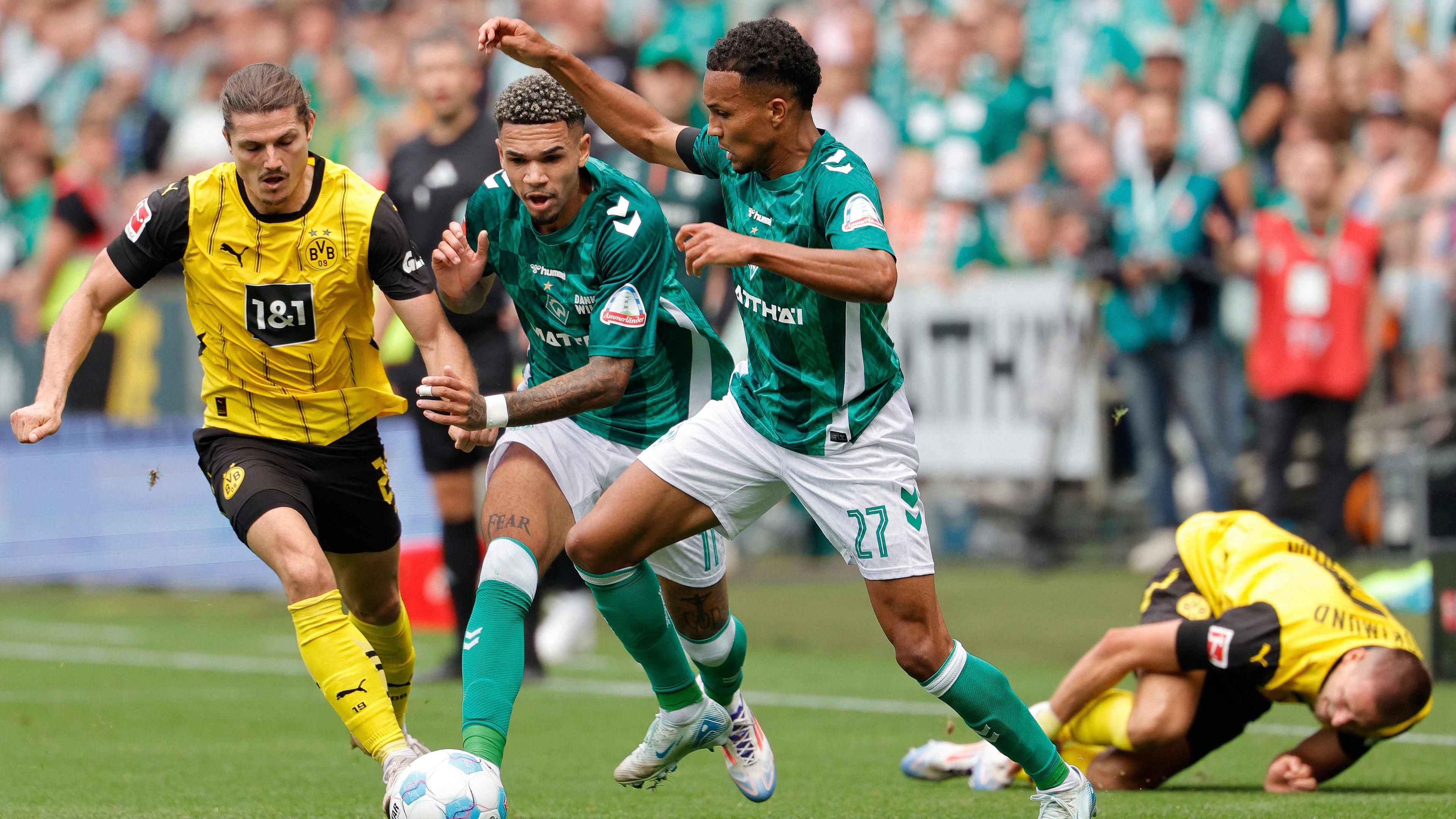 Dortmunds Mittelfeldspieler (Nr. 20) Marcel Sabitzer, Bremens Stürmer (Nr. 11) Justin Njinmah und Bremens Verteidiger (Nr. 27) Felix Agu kämpfen um den Ball.