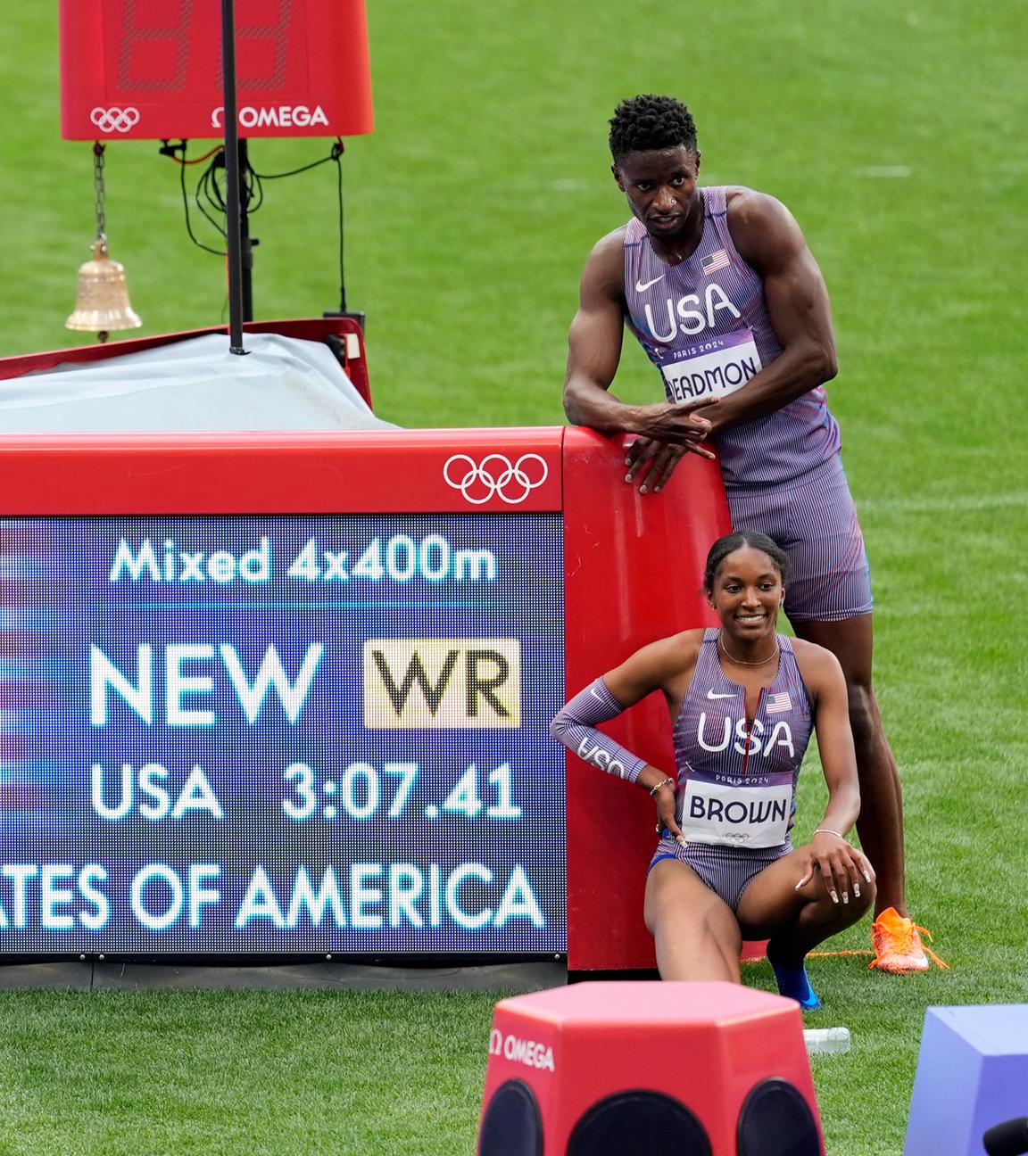 Das Team der USA posiert vor der Anzeigetafel, nachdem sie in der 4x400m Staffel einen neuen Weltrekord erreicht haben.