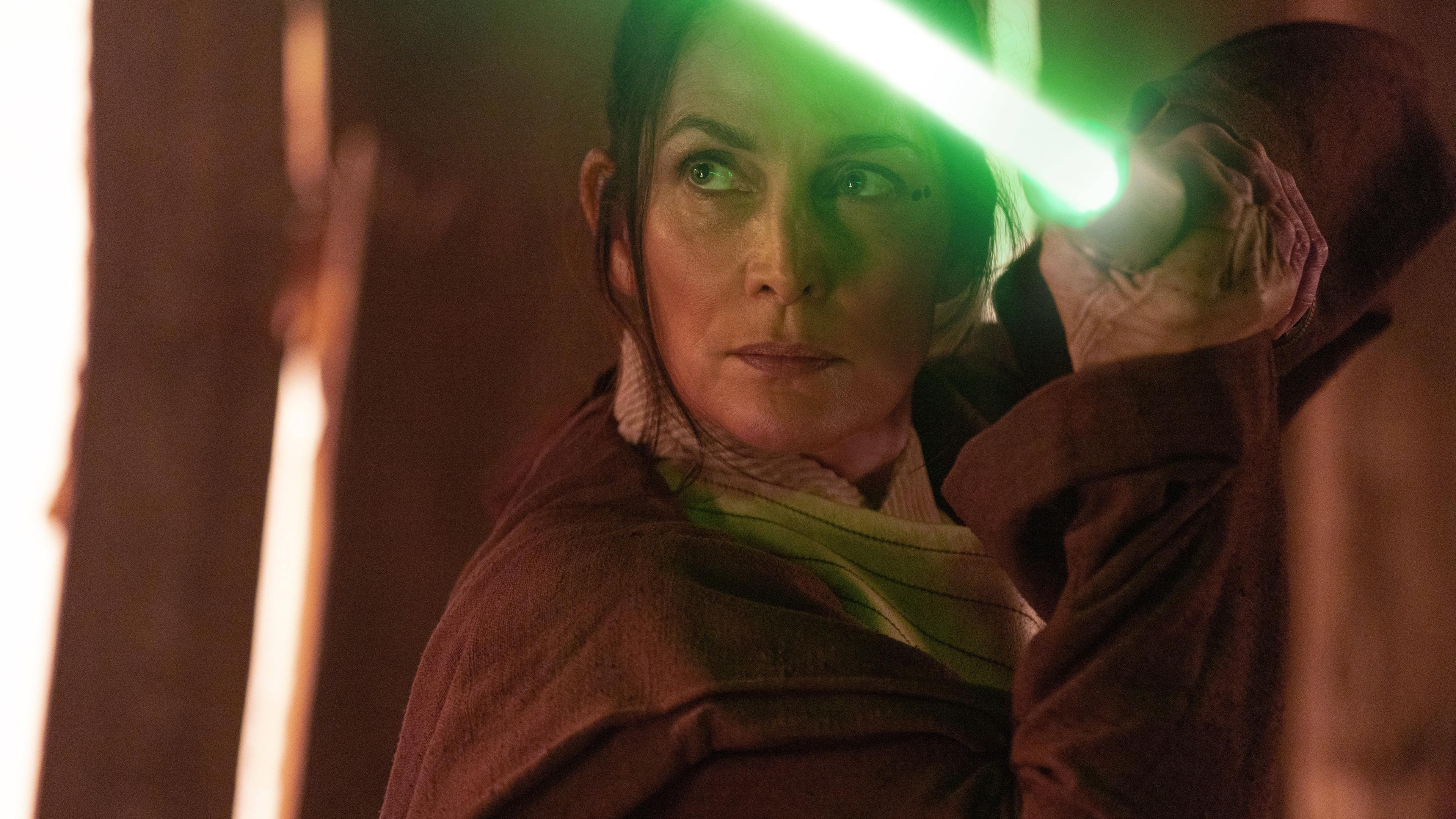 Aufnahme aus Star Wars: The Acolyte, in welcher eine Frau ein Lichtschwert trägt.