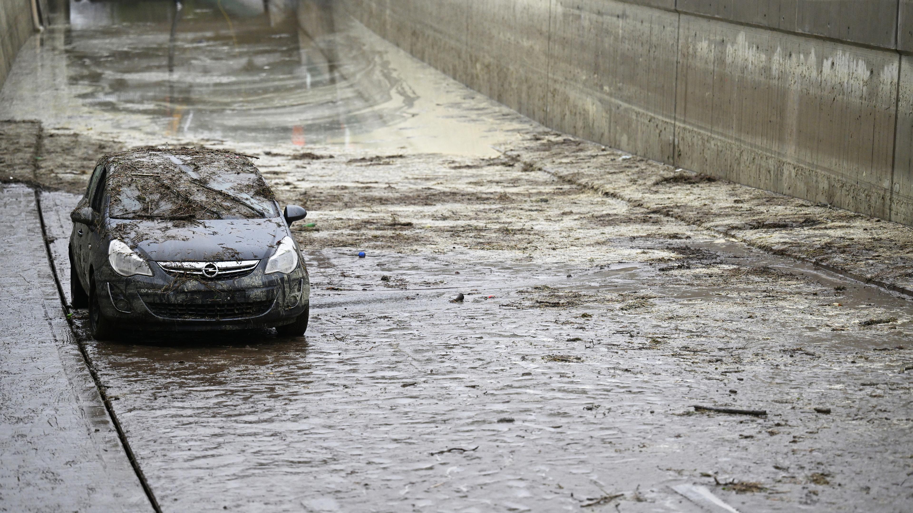 Ein verdrecktes Fahrzeug steht in der noch teilweise überfluteten Unterführung der Bundesstraße B23. Die Straßenunterführung war nach Starkregen vollgelaufen. Archivbild: Mai 2022