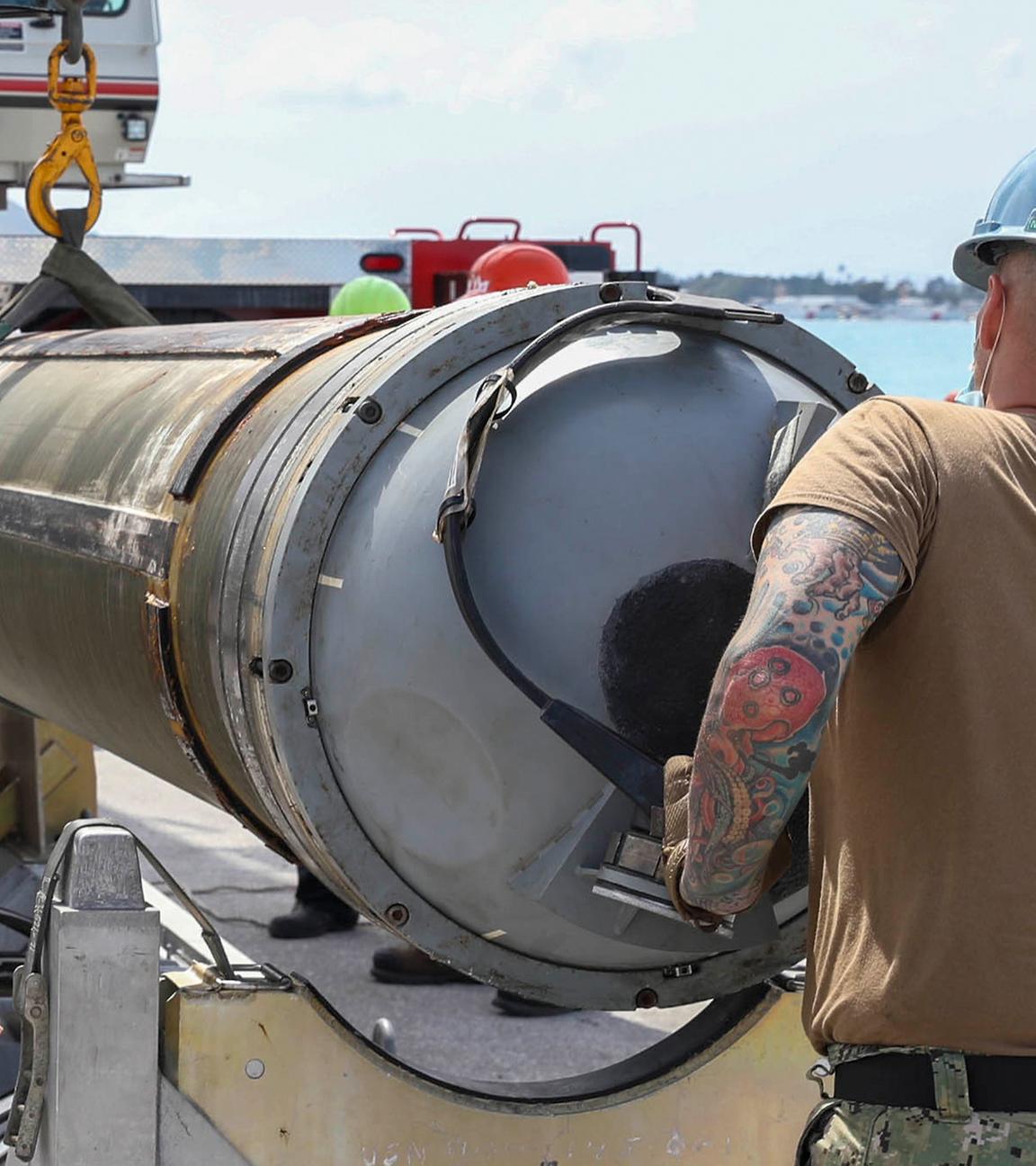 Auf diesem von der Marine der USA zur Verfügung gestellten Bild entladen Matrosen des U-Boot-Tenders USS Emory S. Land (AS 39), Abteilung Waffenhandhabung, eine Tomahawk-Rakete vom Schnellangriffs-U-Boot USS Asheville (SSN 758) der Los Angeles-Klasse.