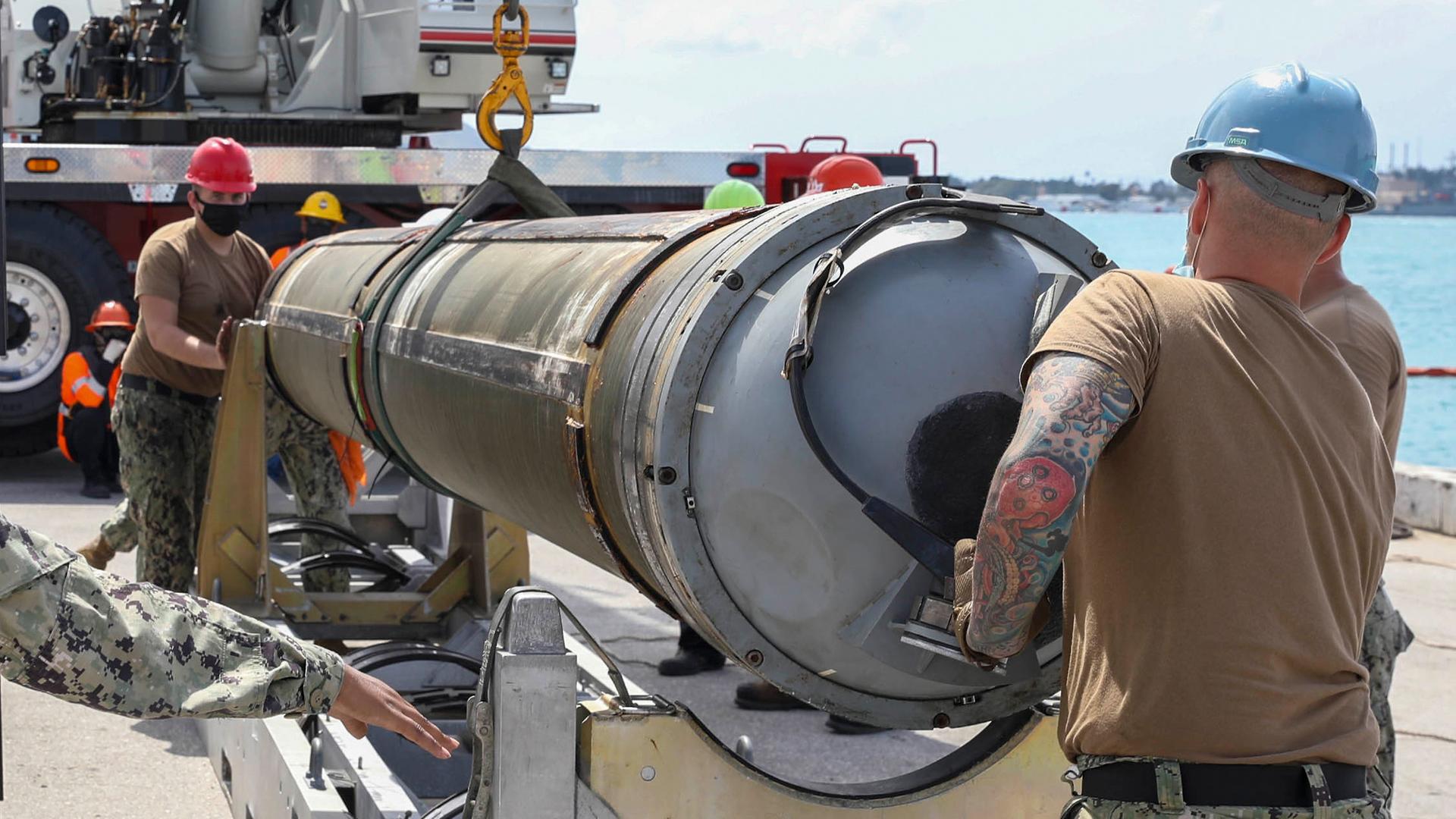 Auf diesem von der Marine der USA zur Verfügung gestellten Bild entladen Matrosen des U-Boot-Tenders USS Emory S. Land (AS 39), Abteilung Waffenhandhabung, eine Tomahawk-Rakete vom Schnellangriffs-U-Boot USS Asheville (SSN 758) der Los Angeles-Klasse.