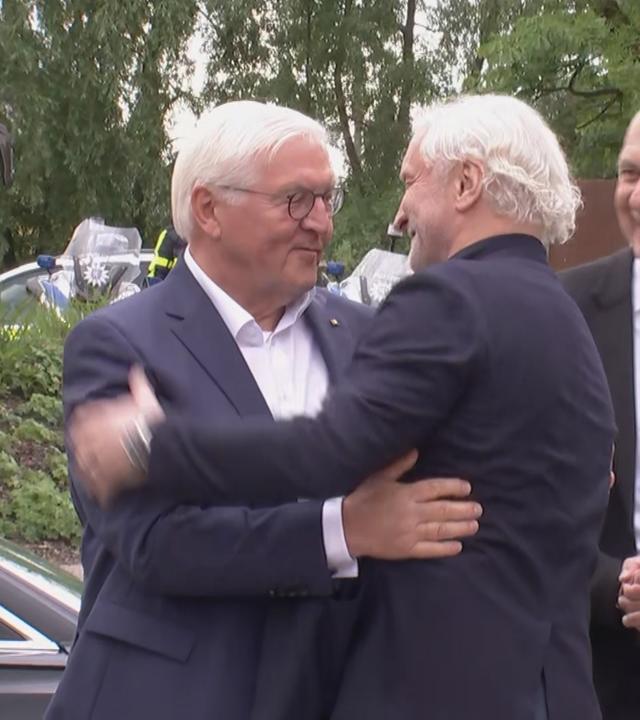 Rudi Völler begrüßt Bundespräsident Frank-Walter Steinmeier mit einer Umarmung.