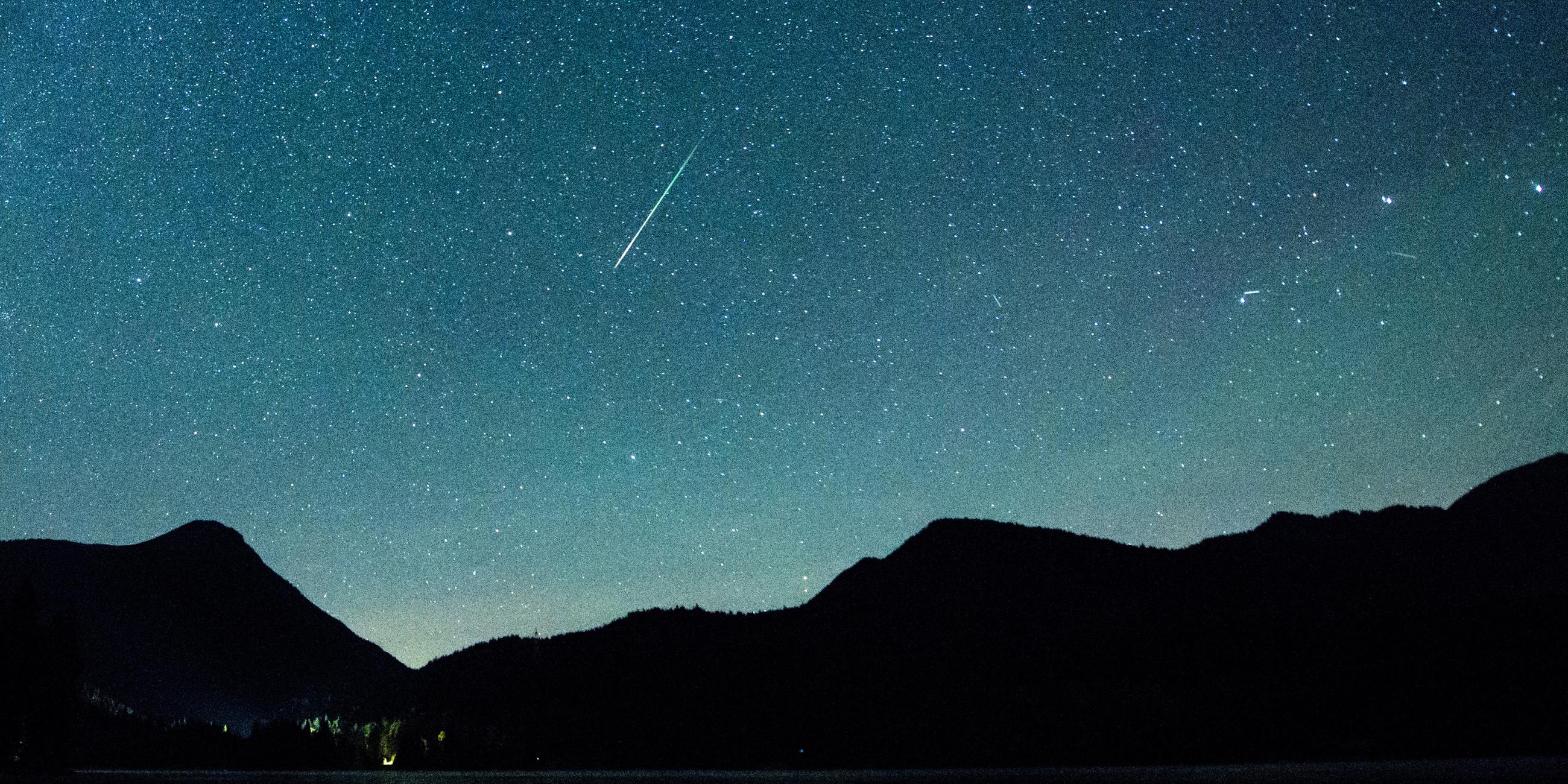 Bayern, Einsiedl: Eine Sternschnuppe leuchtet neben der Milchstraße am Himmel über dem Walchensee.