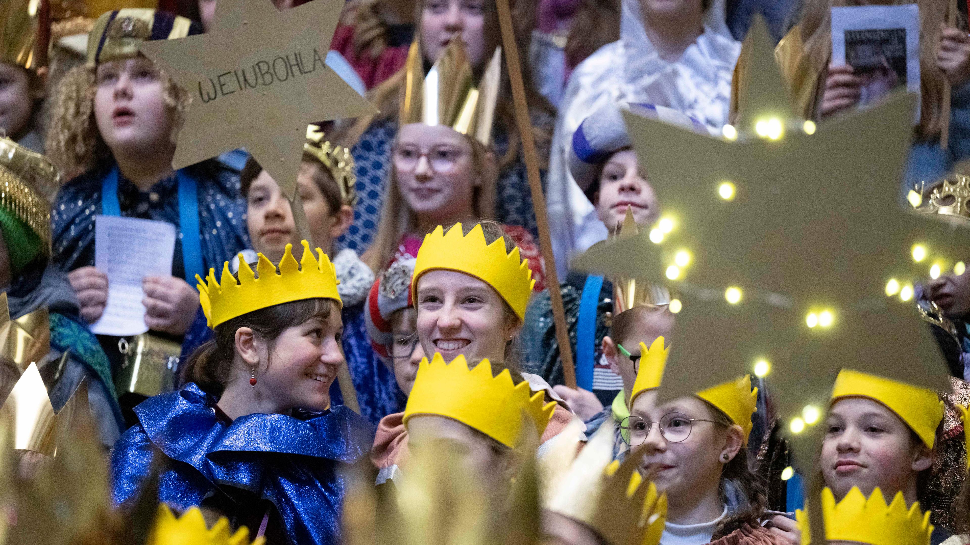 Mehrere Kinder, die als Sternsinger verkleidet sind stehen beisammen.