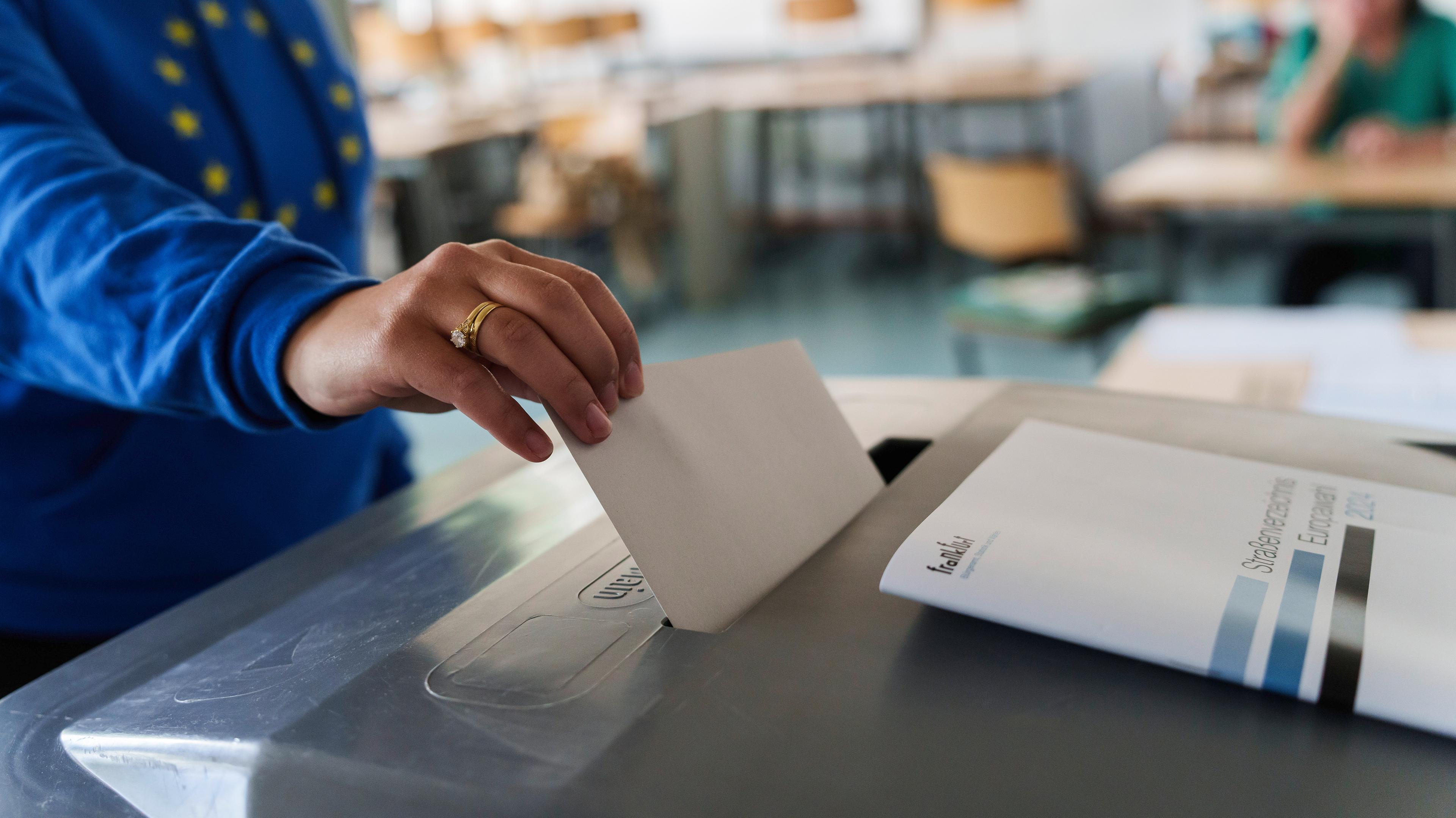 Ein Wahlberechtigter wirft in einem Wahllokal seinen Stimmzettel in eine Wahlurne.