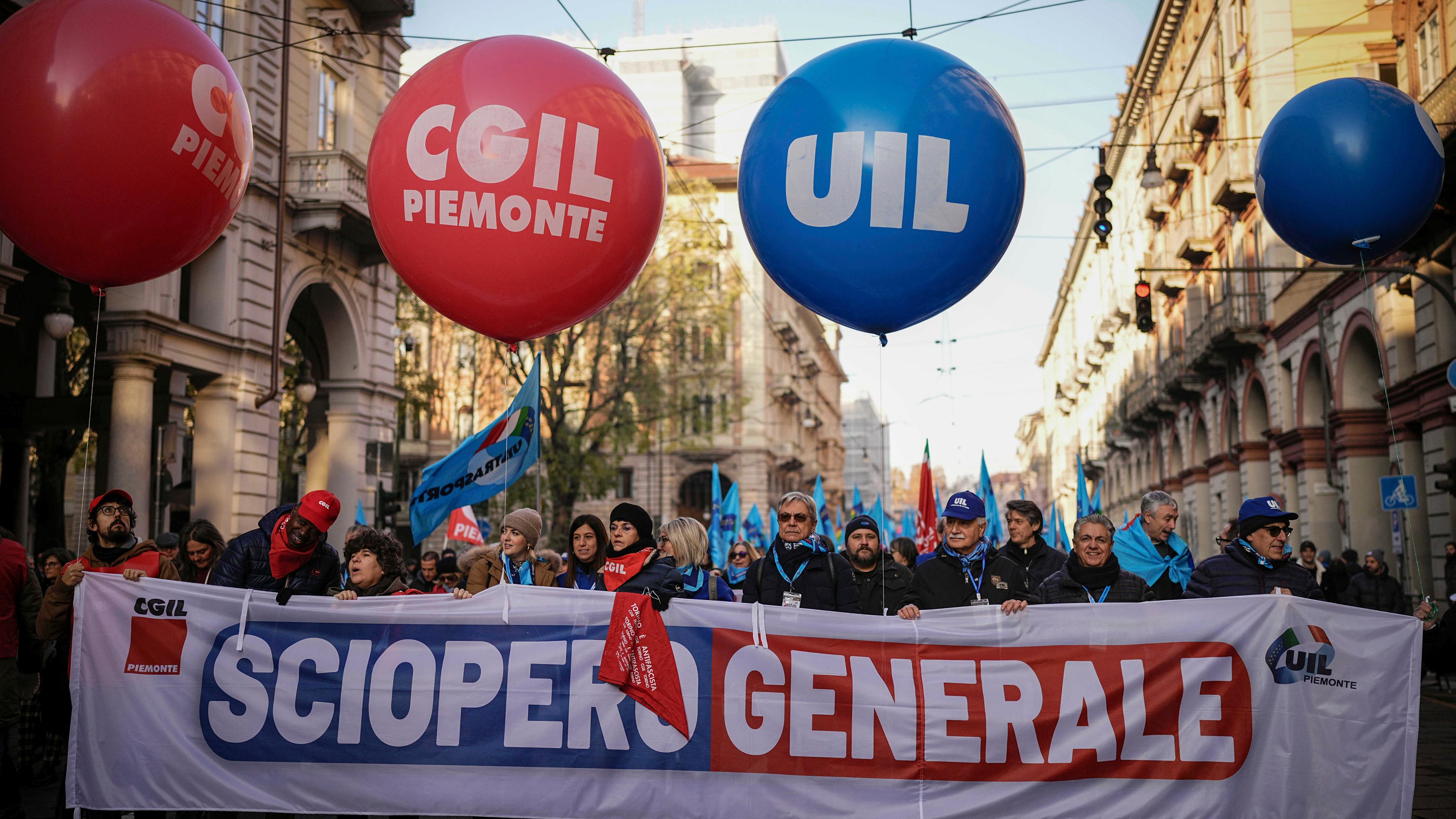 Demonstranten gehen hinter einem Banner mit der Aufschrift "Generalstreik".