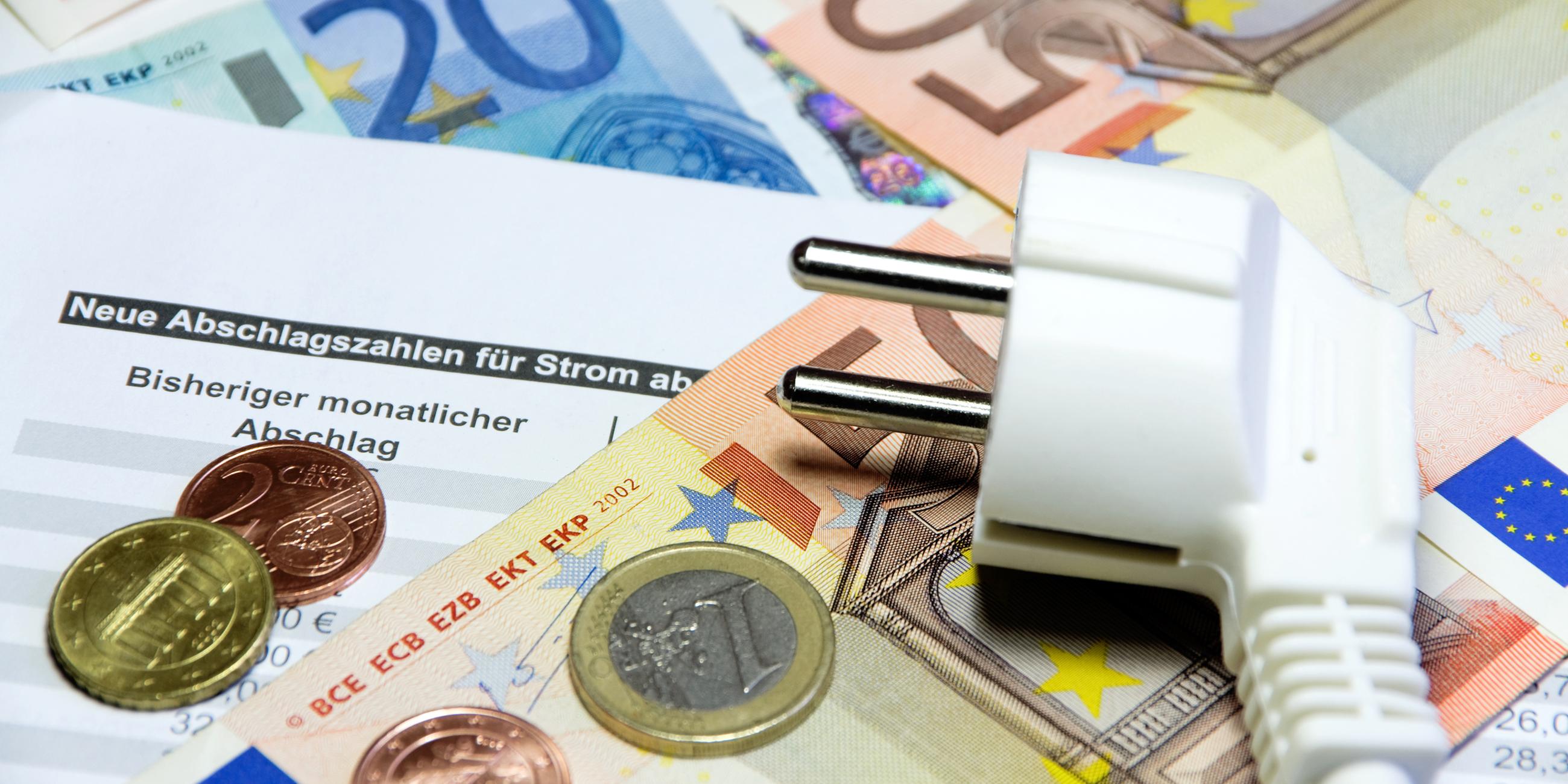Ein Stromstecker liegt auf Euro-Geldscheinen