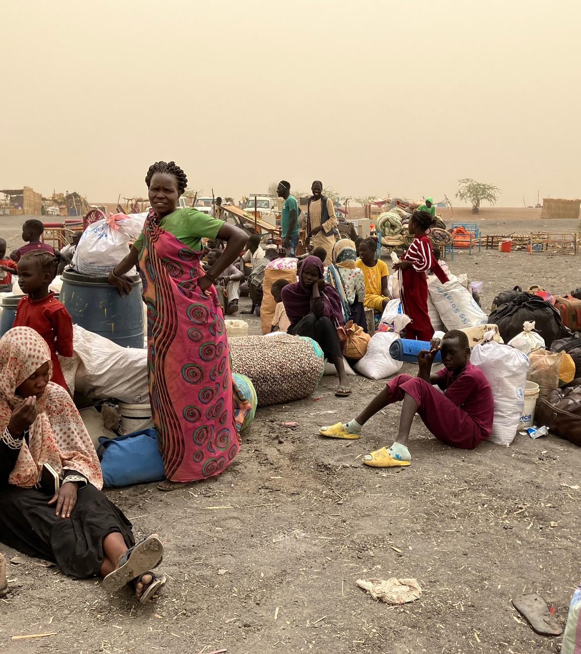 19.03.2024, Südsudan, Renk: Flüchtlinge aus dem Sudan warten nach der Überquerung der Grenze in den Südsudan auf einen Transport in das Transitlager der grenznahen Stadt Renk.