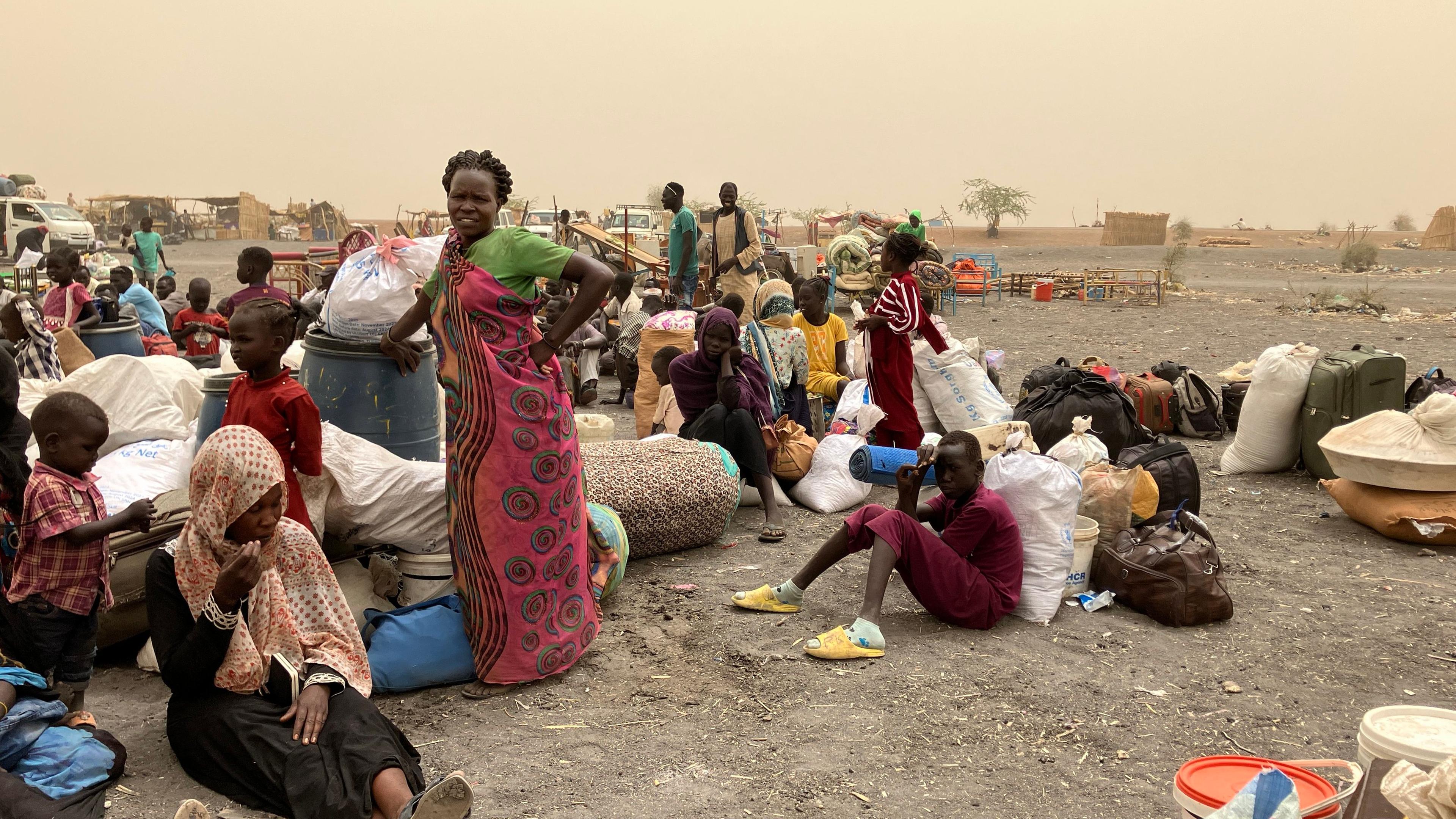 19.03.2024, Südsudan, Renk: Flüchtlinge aus dem Sudan warten nach der Überquerung der Grenze in den Südsudan auf einen Transport in das Transitlager der grenznahen Stadt Renk.