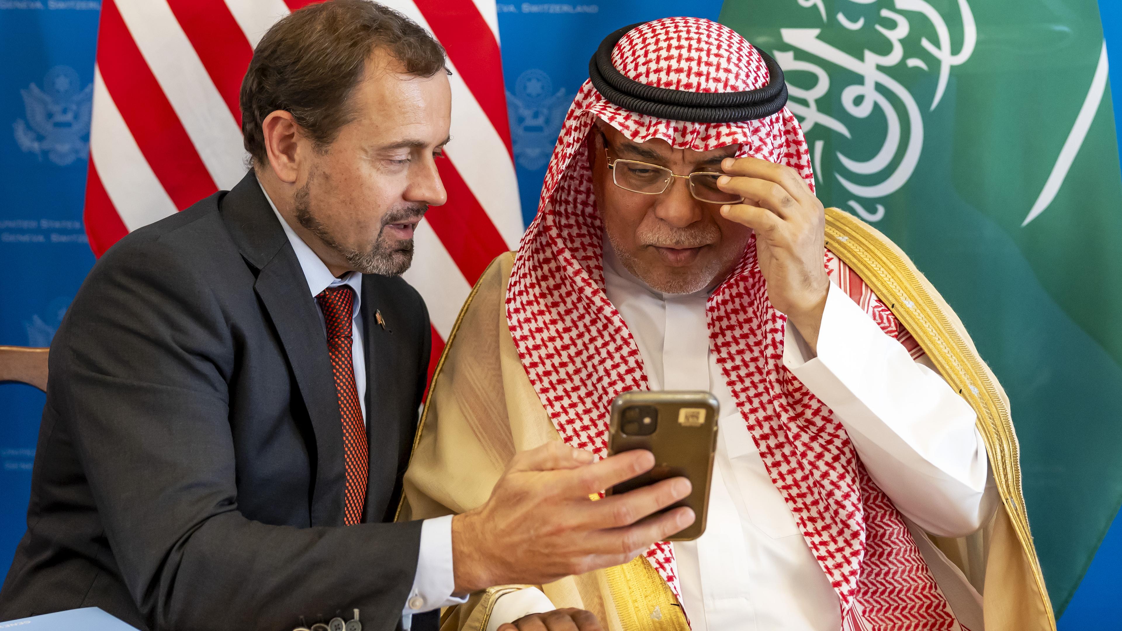 Schweiz, Genf: Der US-Sondergesandte für den Sudan, Tom Perriello (l) zeigt Bilder auf seinem Smartphone, während der Leiter der saudi-arabischen Delegation, Ali bin Hassan Jafar (r) nach einer Gesprächsrunde über die Einstellung der Feindseligkeiten im Sudan nach einer Pressekonferenz.