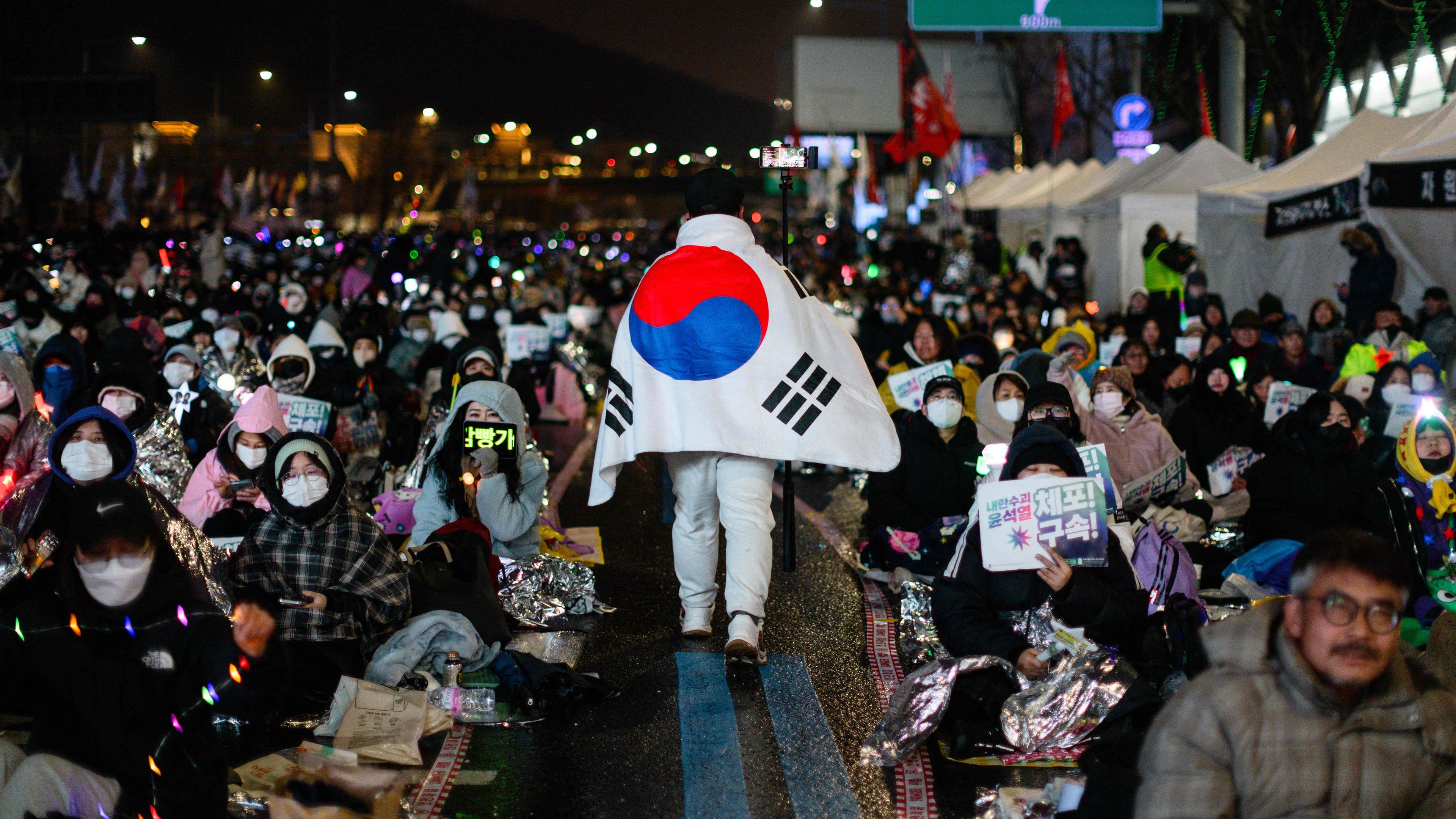 Südkorea, Seoul: Menschen nehmen am 5. Januar 2025 an einer Kundgebung gegen den angeklagten südkoreanischen Präsidenten Yoon Suk Yeol in der Nähe seiner Residenz teil.