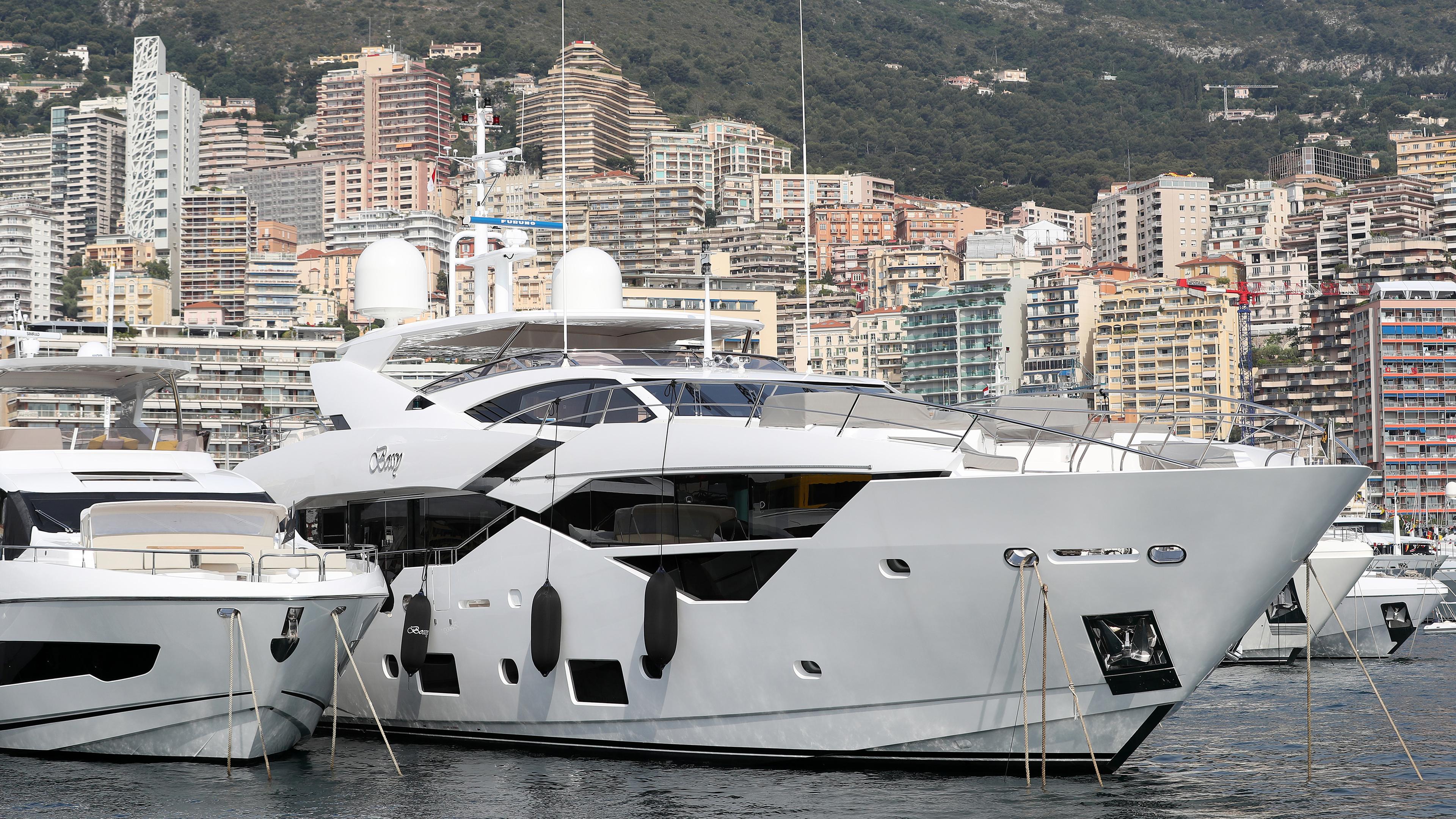 Luxusjachten liegen im Hafen von Monaco, mit der Stadt im Hintergrund.