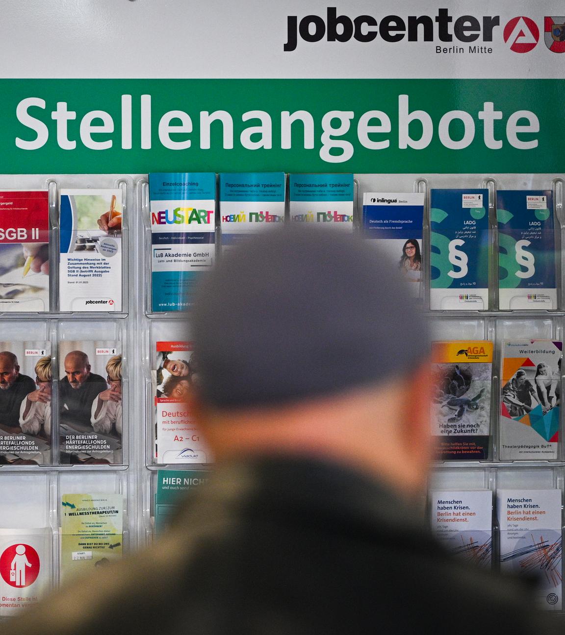 Flyer werden auf einer Tafel mit der Überschrift Aktuelle Stellenangebote im Jobcenter Berlin Mitte am Tag der Möglichkeiten angeboten