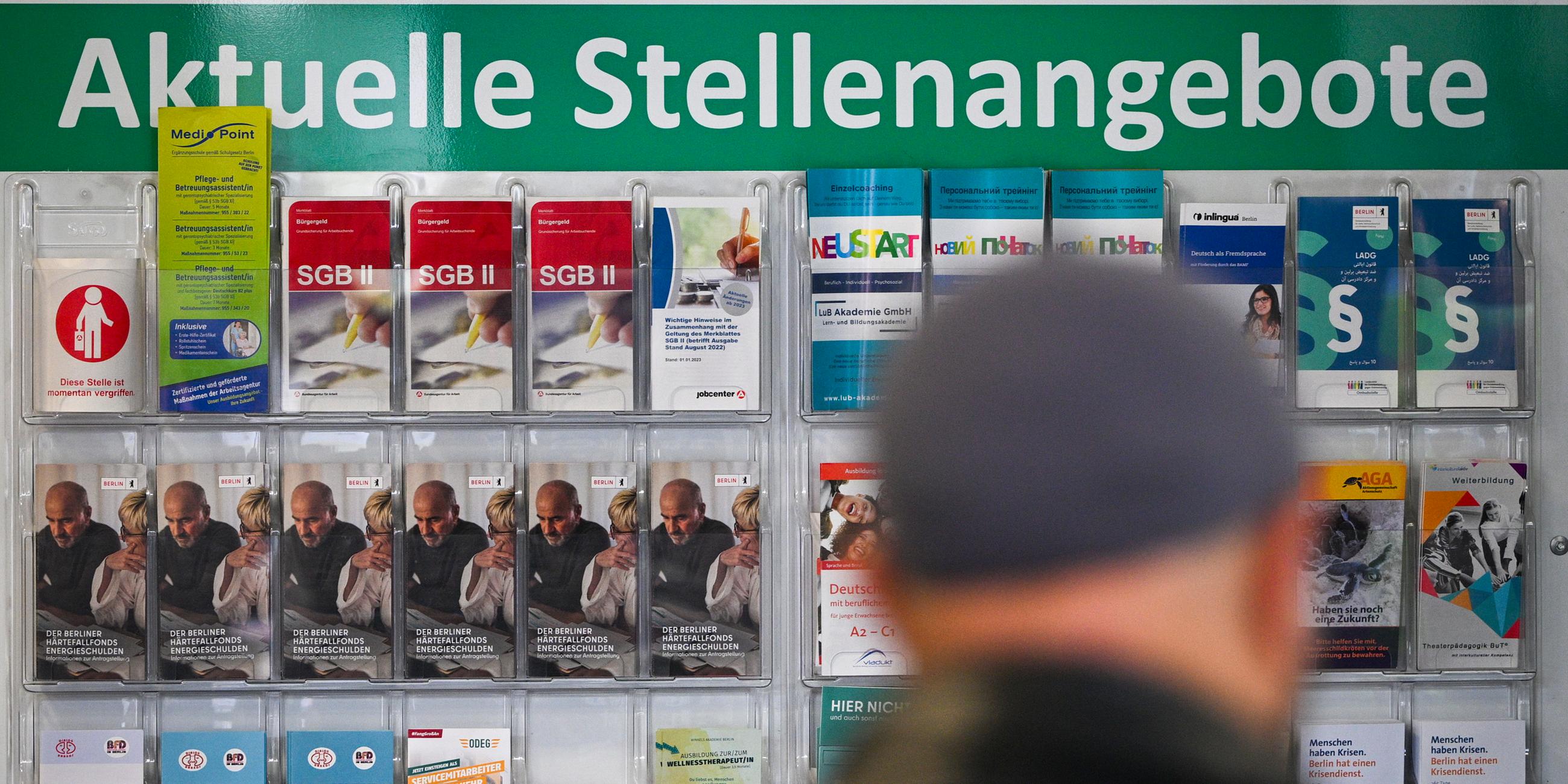 Flyer werden auf einer Tafel mit der Überschrift Aktuelle Stellenangebote im Jobcenter Berlin Mitte am Tag der Möglichkeiten angeboten