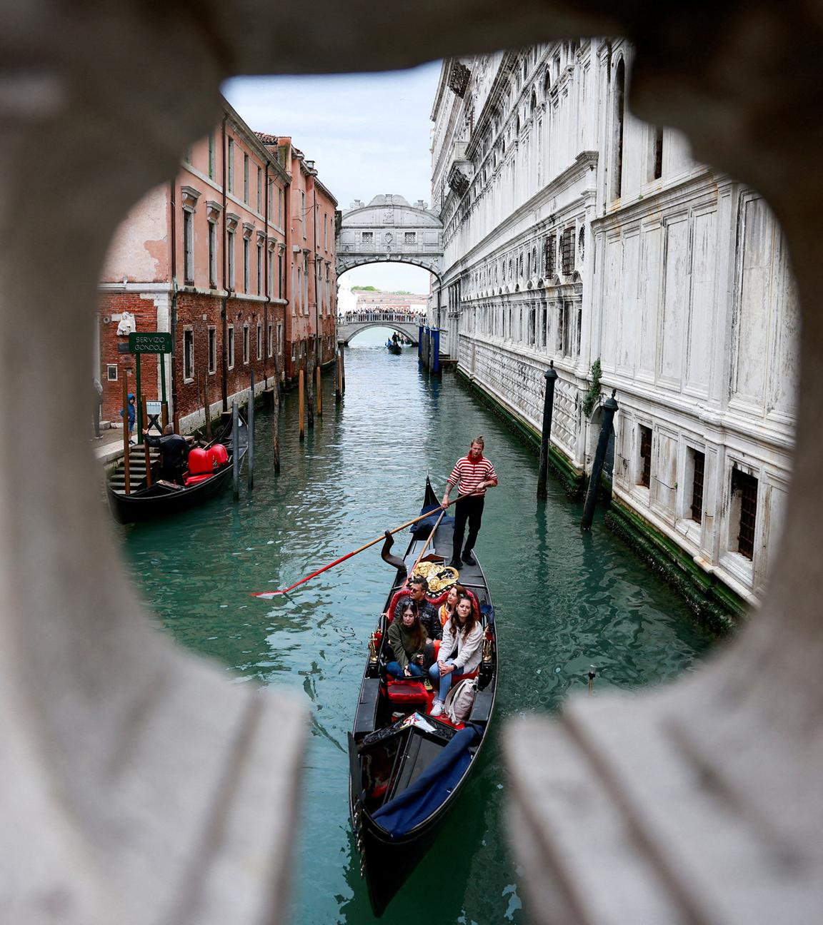 Ein Gondoliere rudert seine Gondel durch den Kanal von Venedig