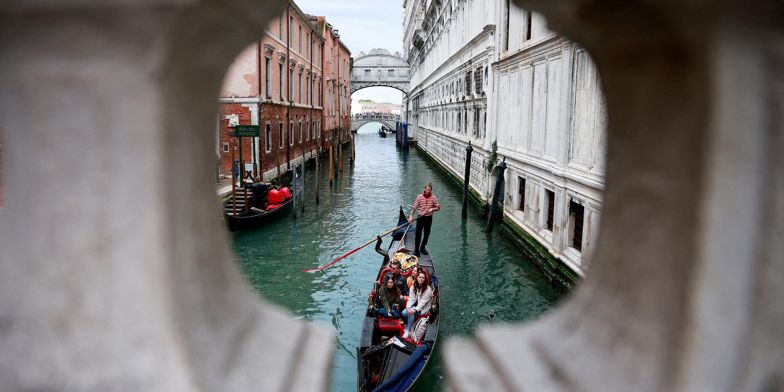 Ein Gondoliere rudert seine Gondel durch den Kanal von Venedig
