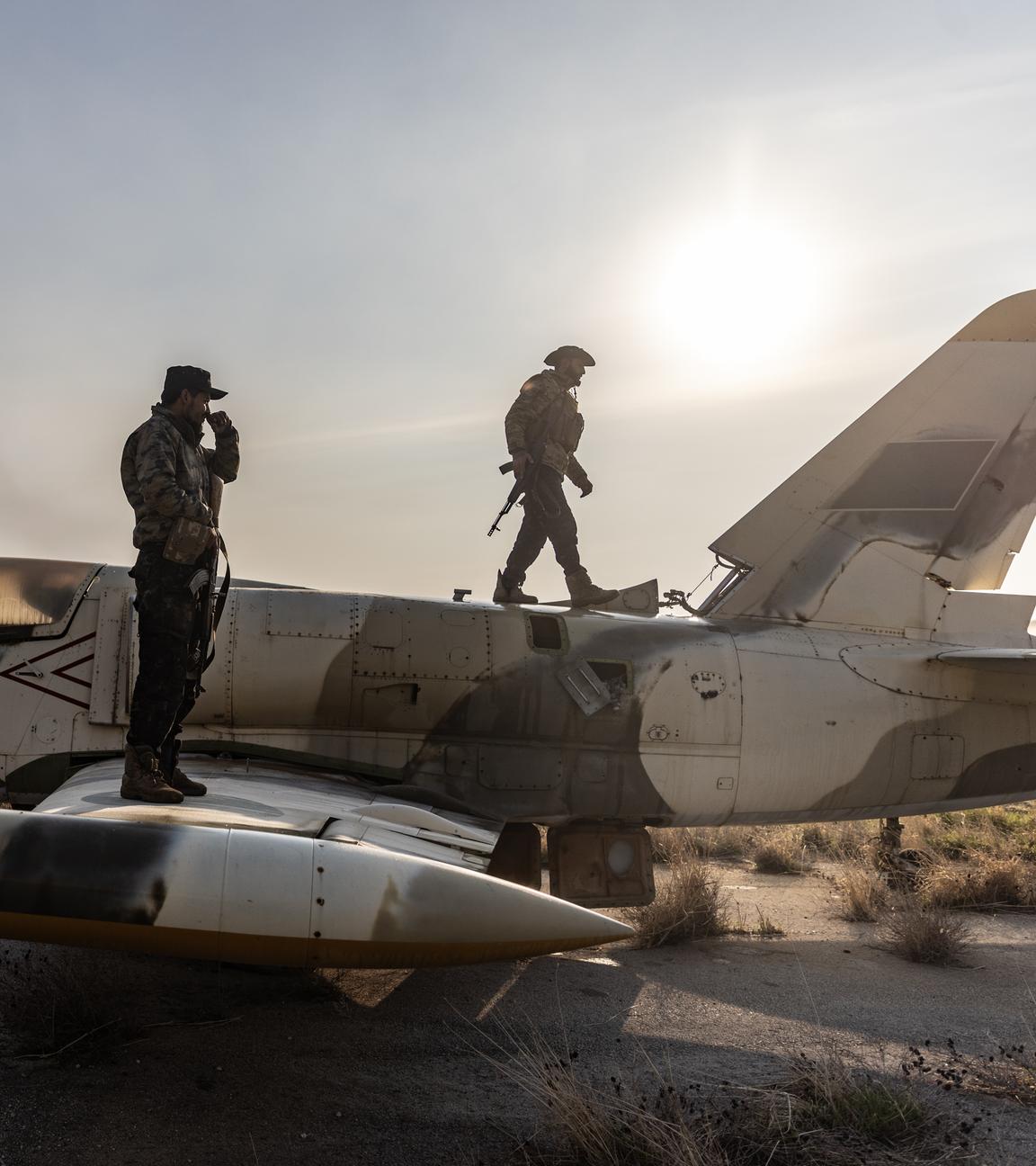 Mitglieder der bewaffneten syrischen Opposition stehen auf einem Militärflugzeug, nachdem sie die Kontrolle über den Militärflughafen Nayrab in der Stadt Aleppo übernommen haben.