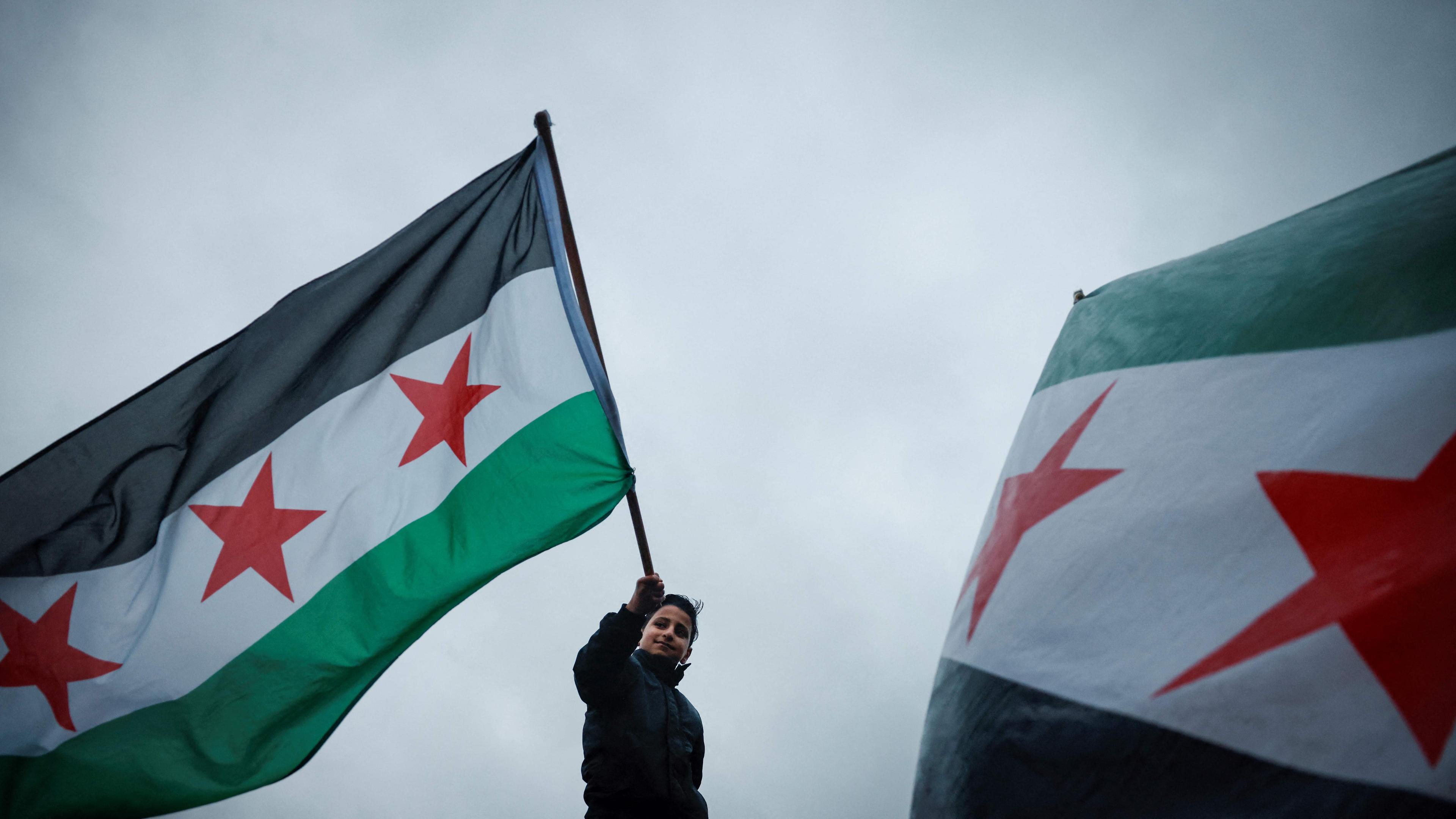 Person schwenkt syrische Flagge