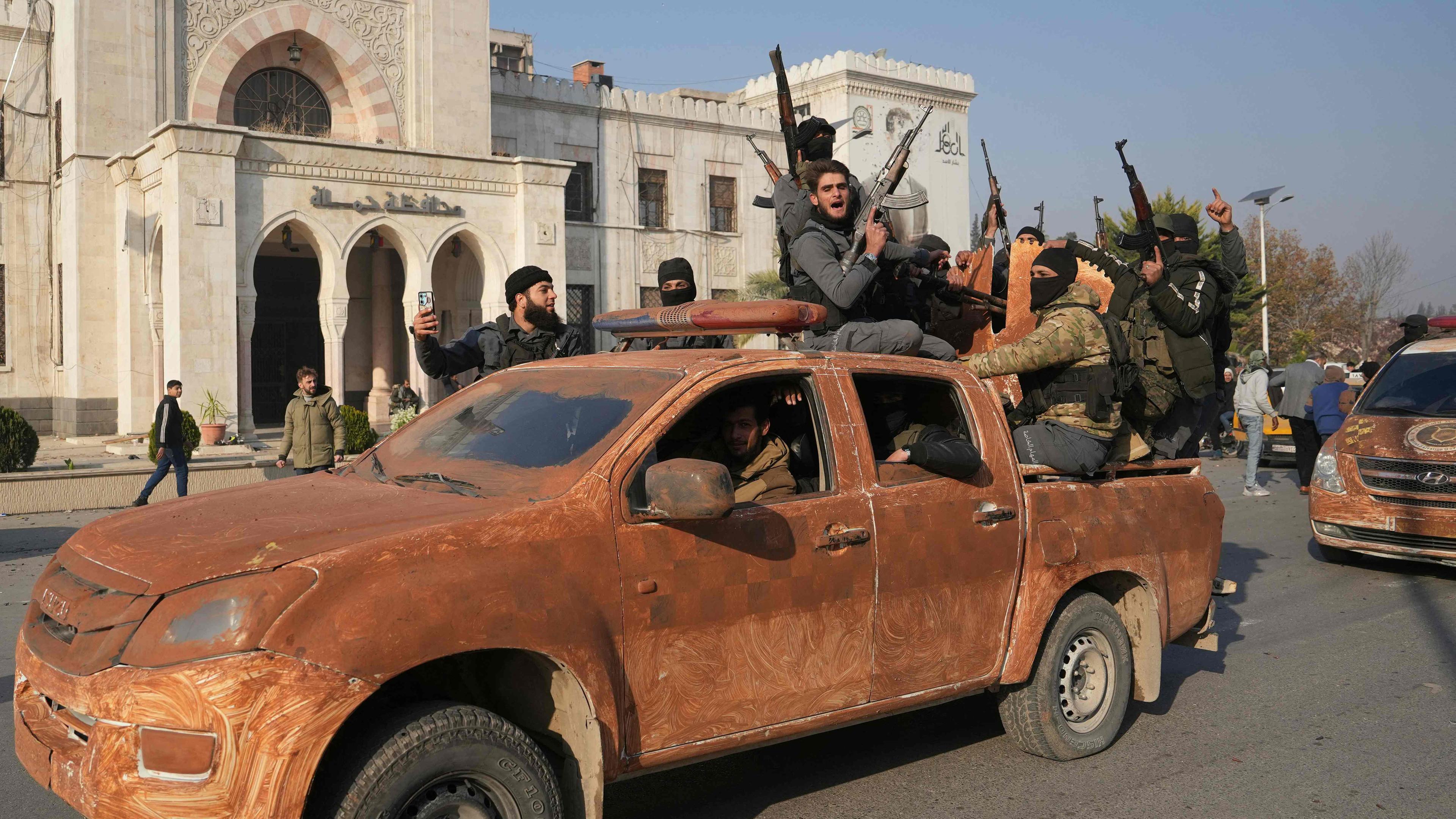 Syrien, Hama: Regierungsfeindliche Kämpfer feiern, als sie in die eroberte zentralwestliche Stadt Hama einfahren