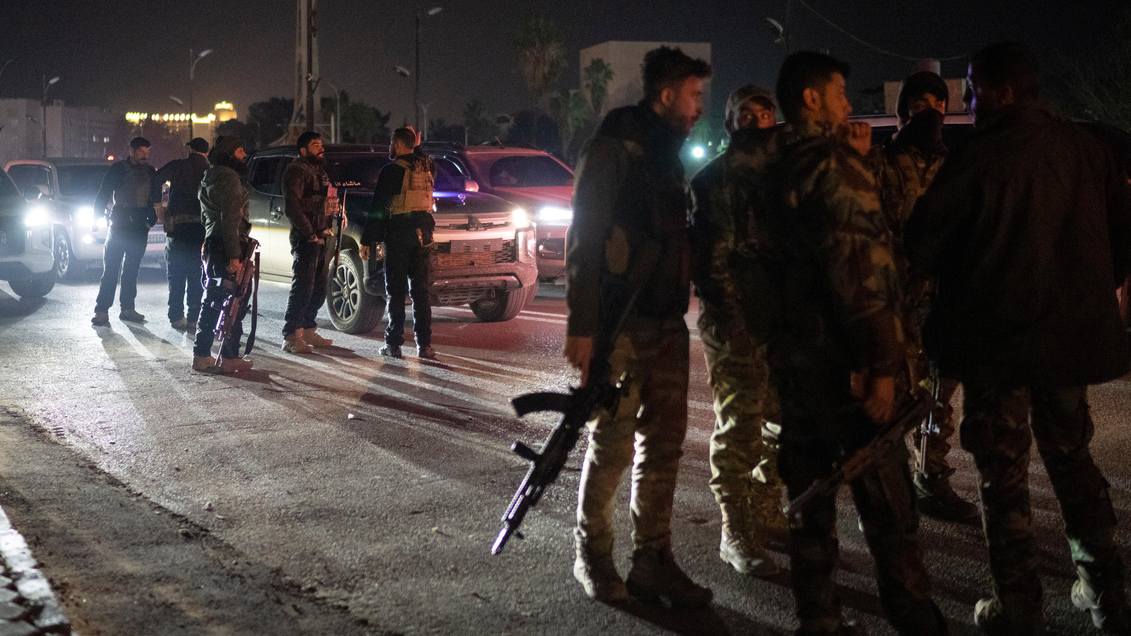  Syrische Kämpfer versammeln sich in der Nacht auf einer Straße in Damaskus.