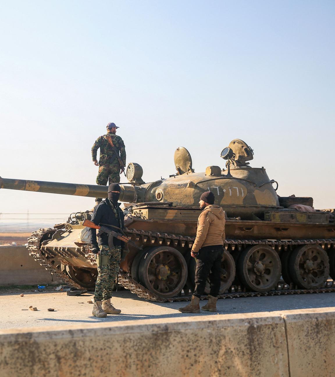 Soldaten untersuchen einen zurückgelassenen Panzer der syrischen Armee in Aleppo, Syrien.