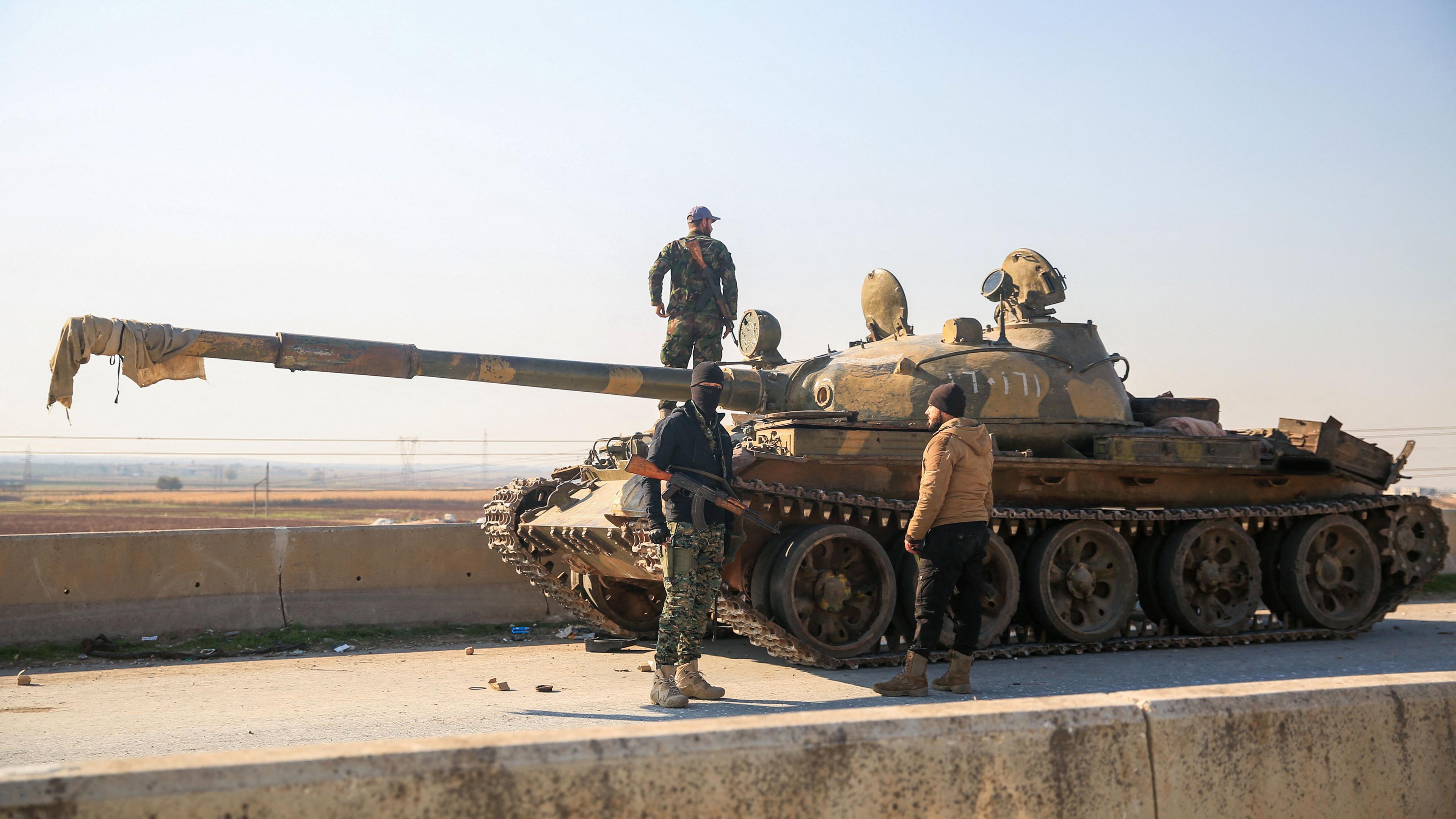 Soldaten untersuchen einen zurückgelassenen Panzer der syrischen Armee in Aleppo, Syrien.