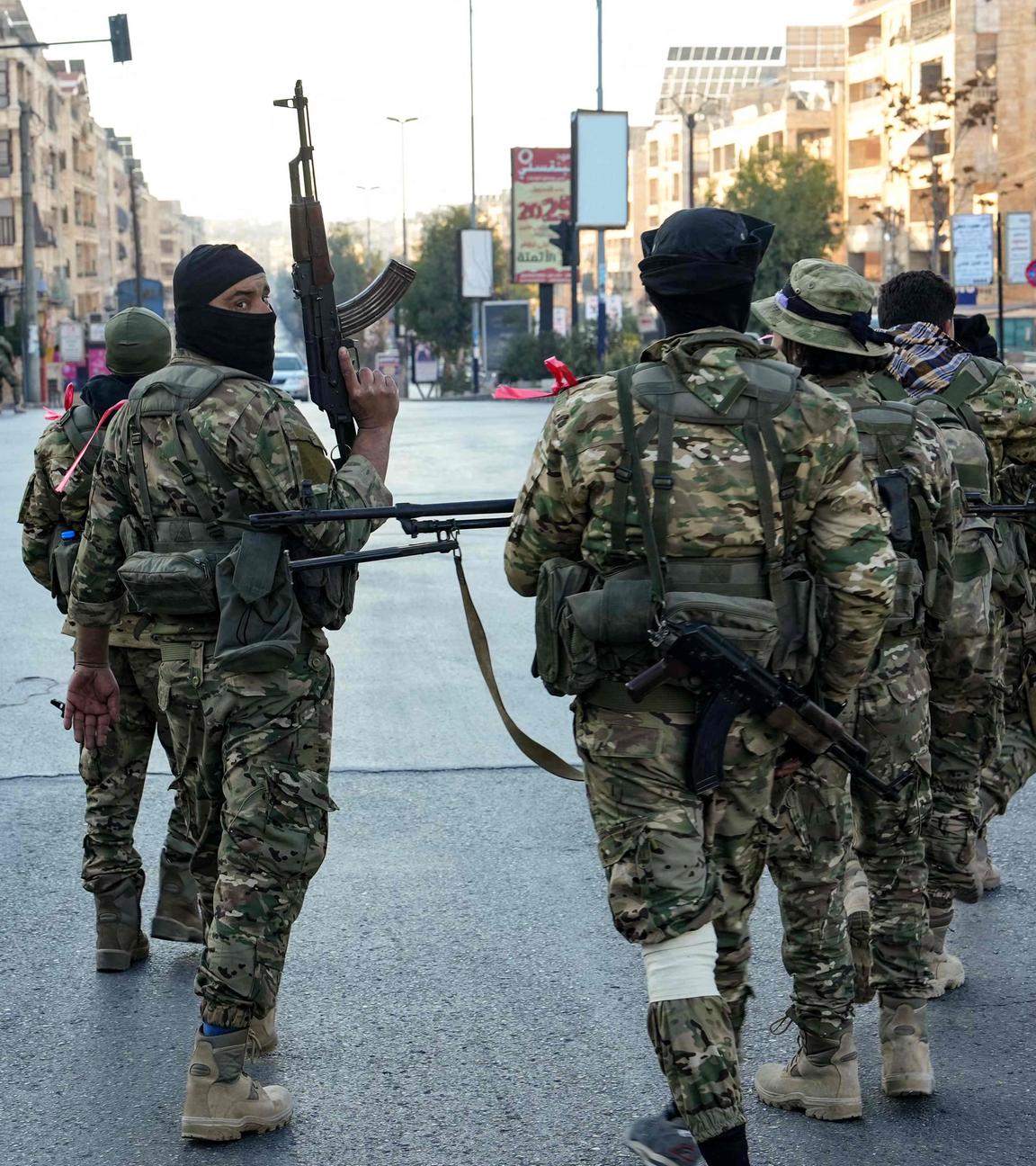 Anti-government fighters patrol in central Aleppo on November 30, 2024. 