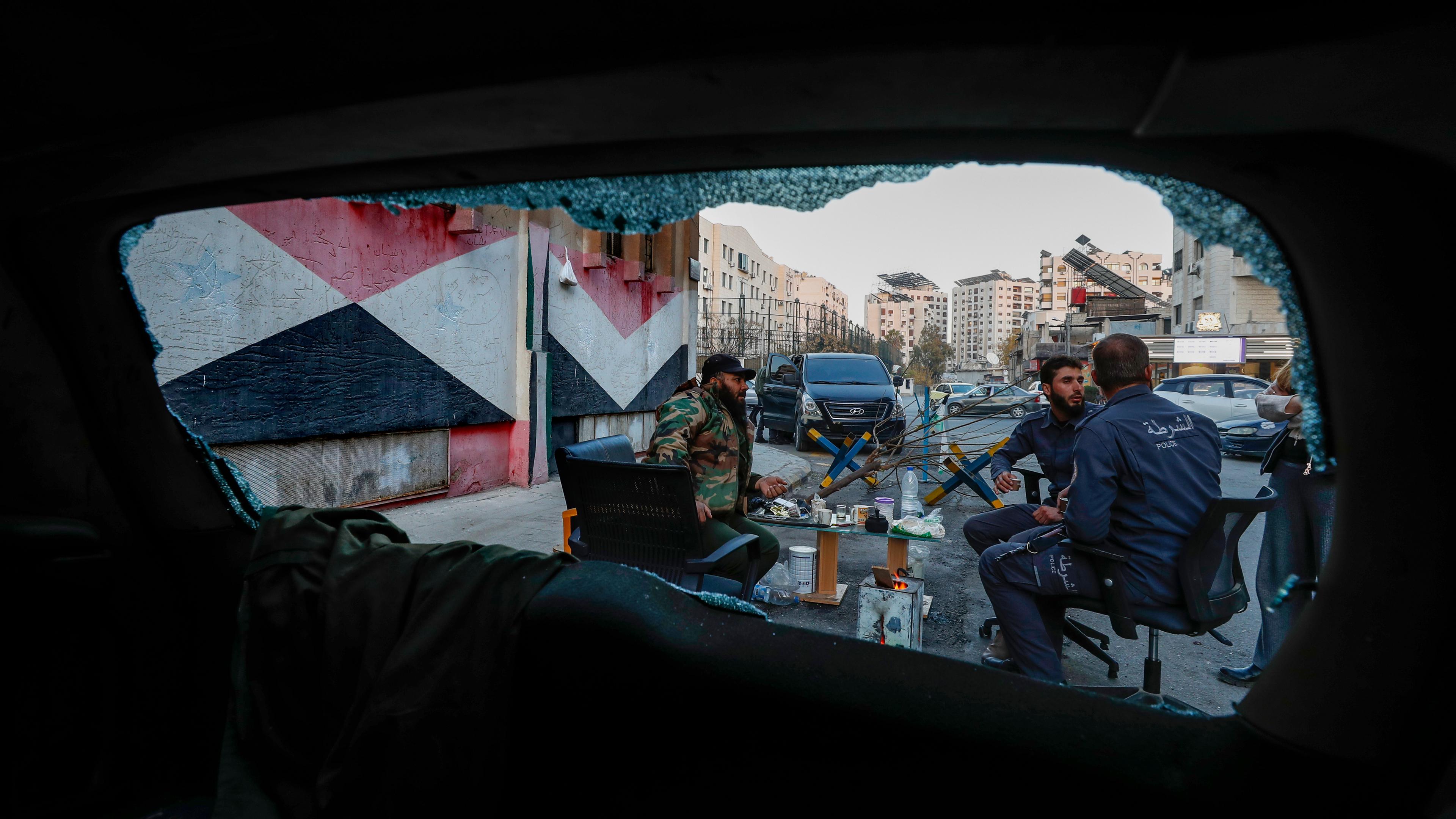 Syrische Kämpfer gesehen durch ein zerbrochenes Autofenster. 