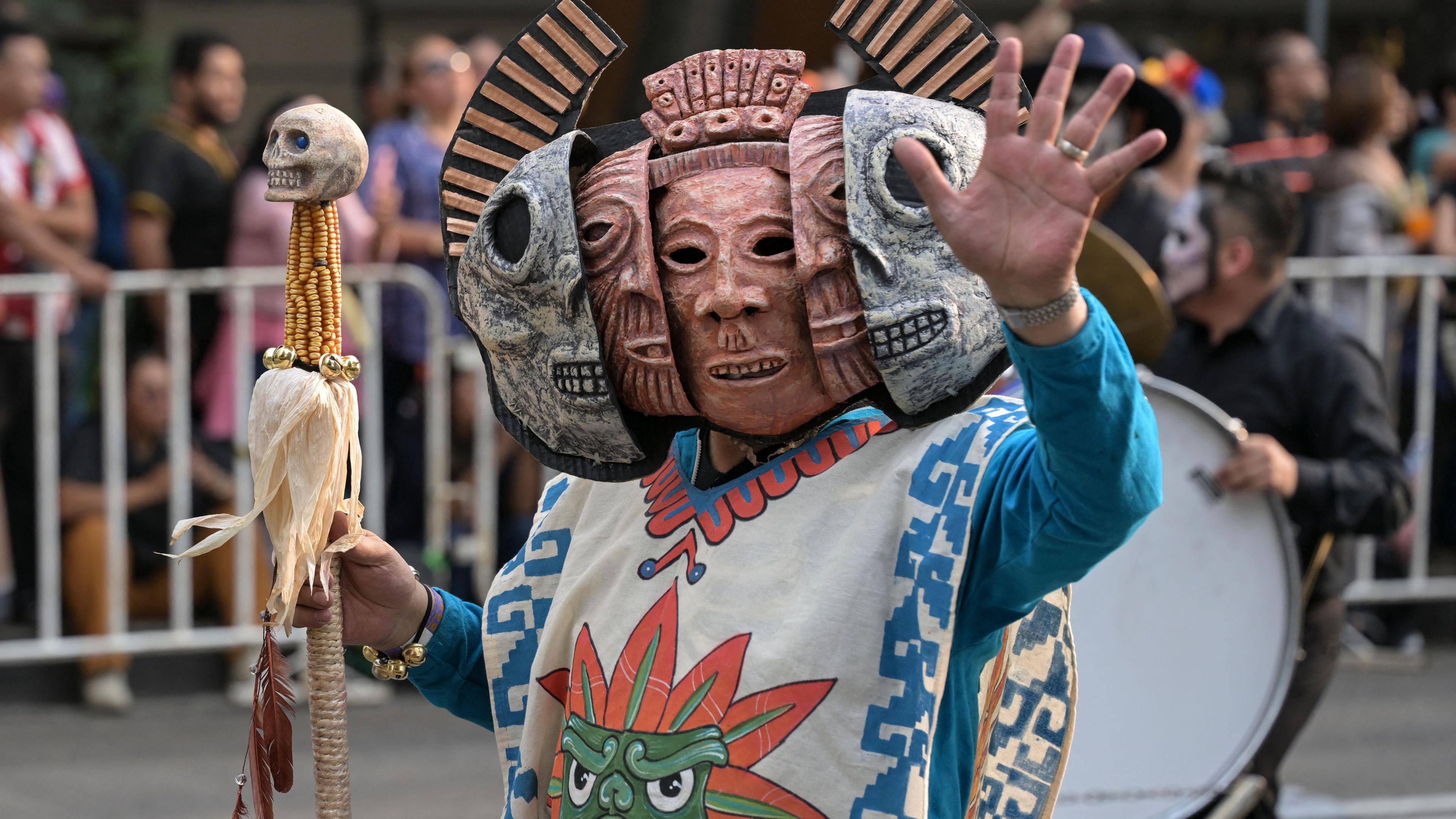 Eine verkleidete Person läuft bei der Parade zum Tag der Toten in Mexiko City.